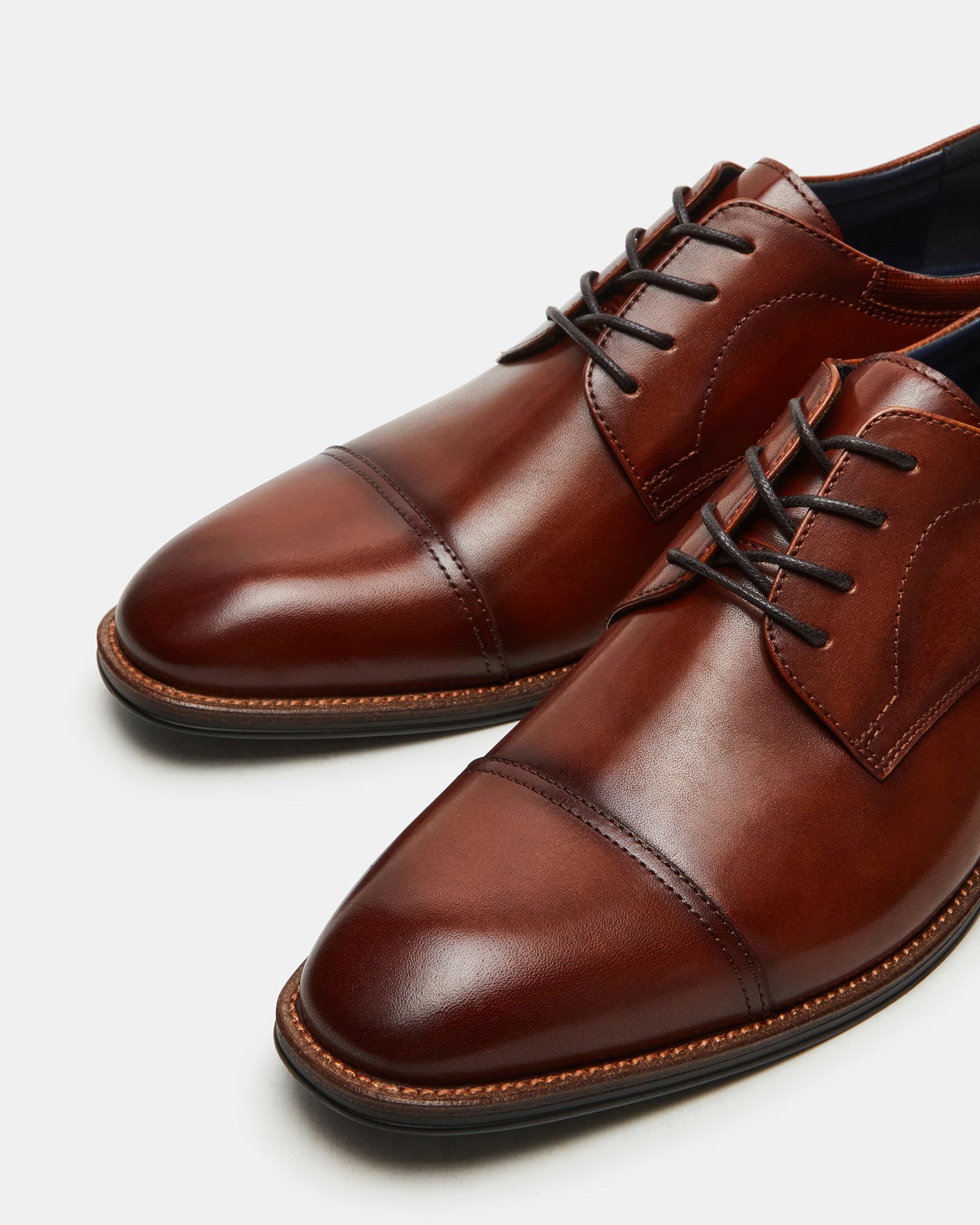 Front view of HASEN tan leather dress shoes on a wooden surface.