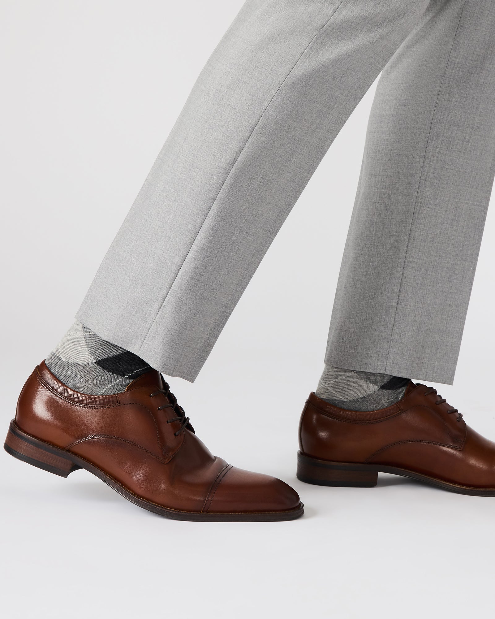 Side angle of tan leather formal shoes, showcasing lace-up design.