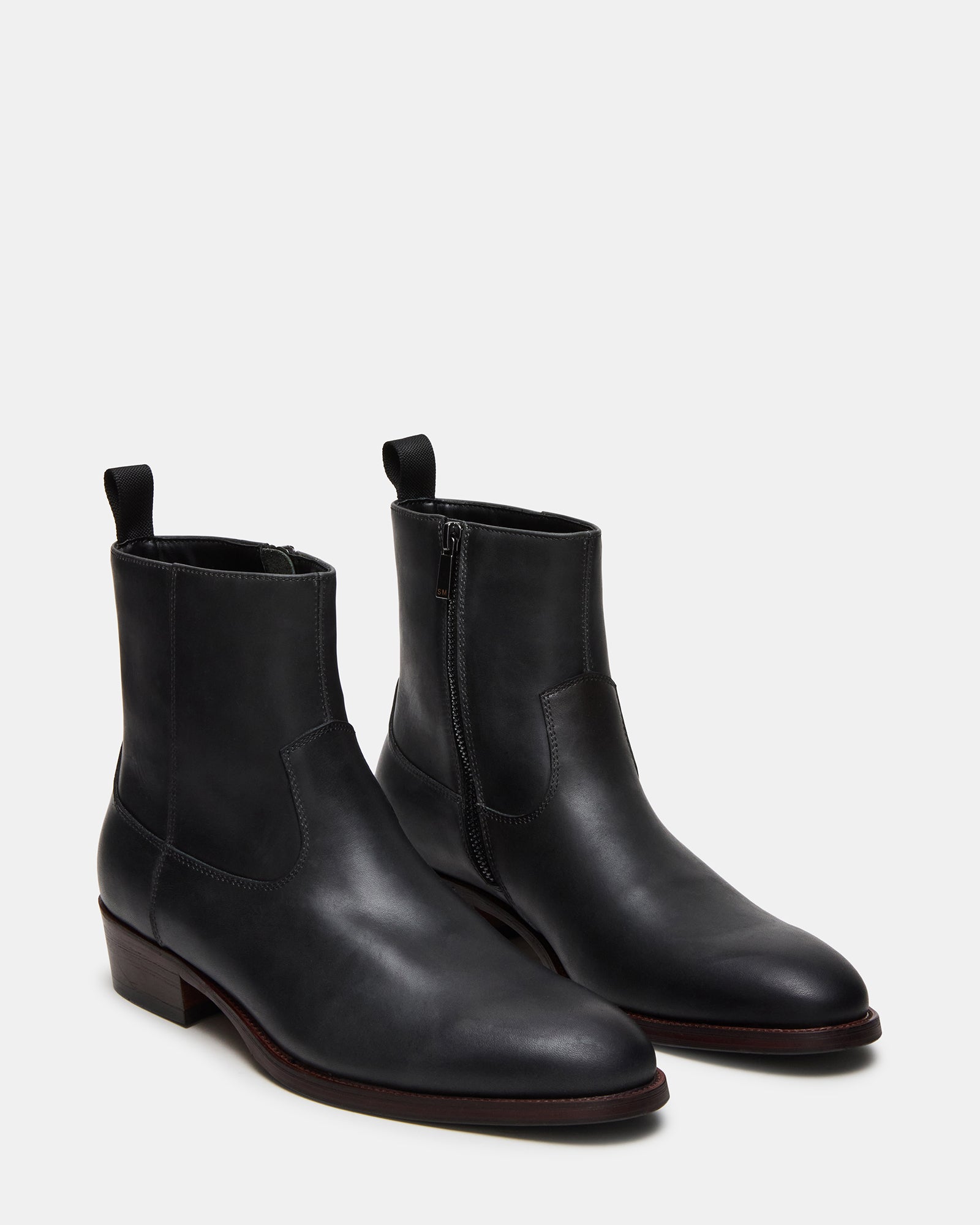 Angled view of the black boots emphasizing heel height and textured sole