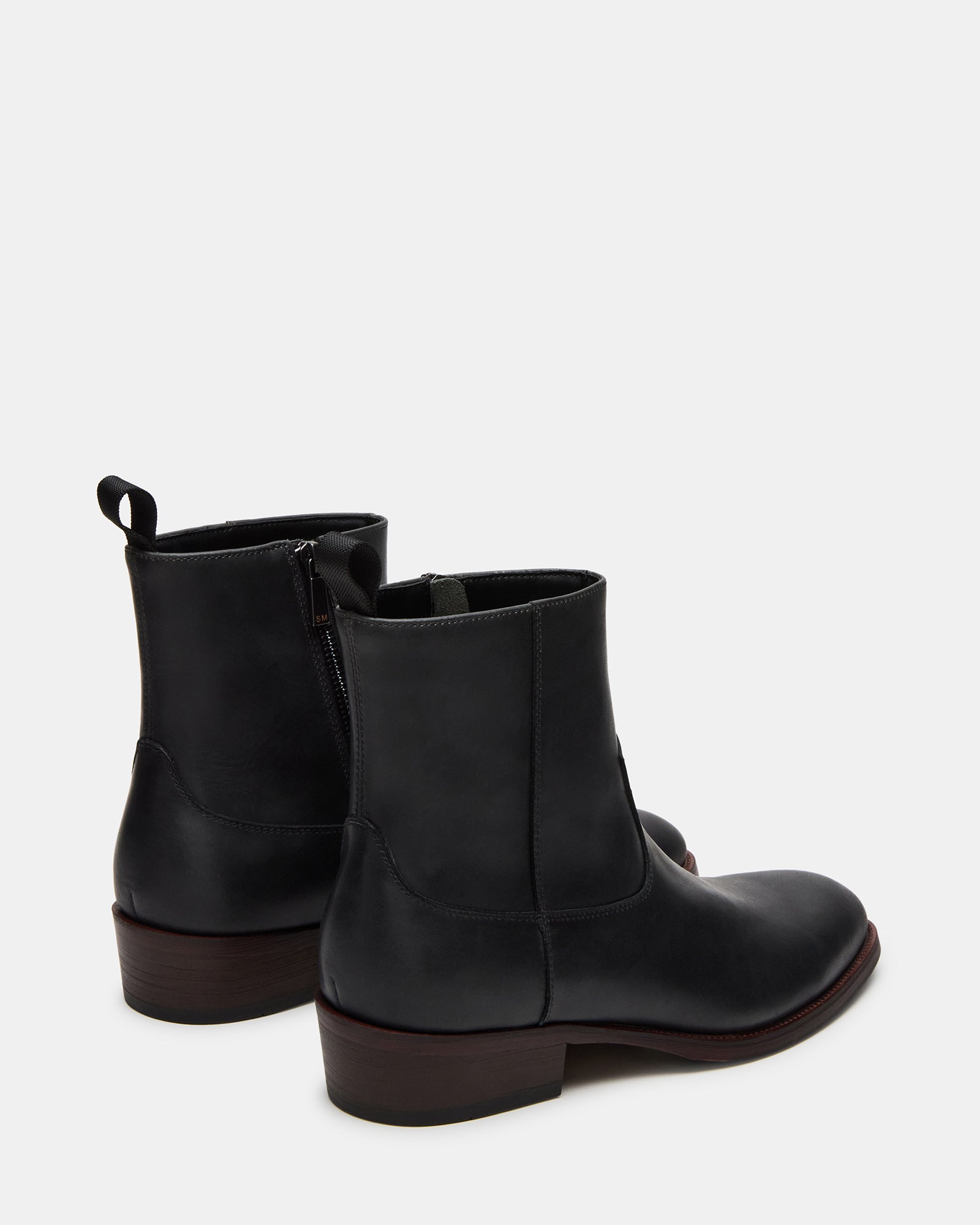 Angled view of the black boots emphasizing heel height and textured sole