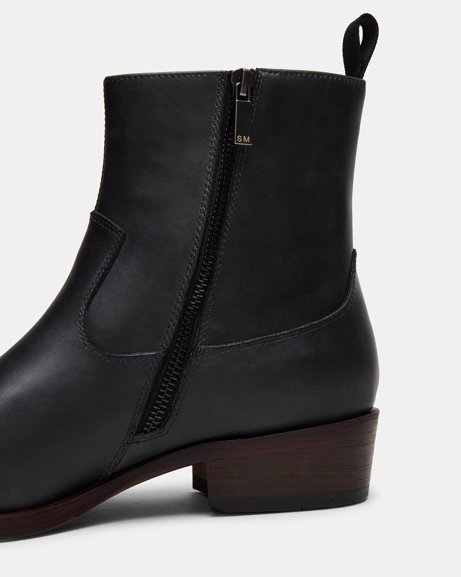 Close-up of Hendrik black leather boots showing polished finish and zip detail