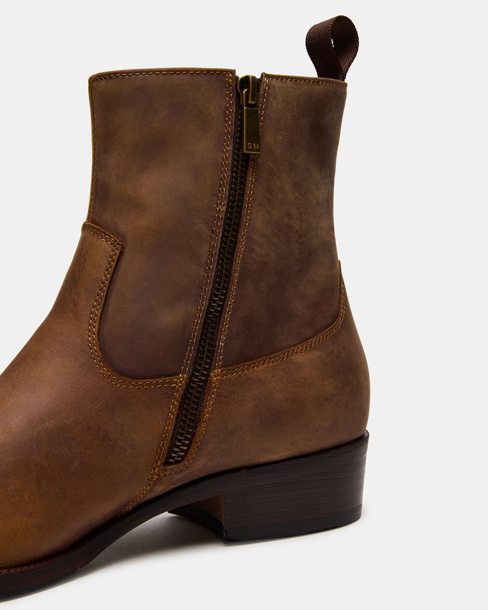 Front view of Hendrik tan leather boots on a wooden floor