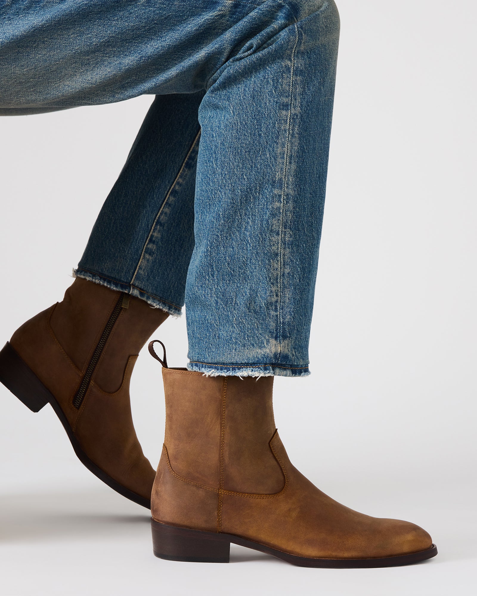 Side angle showcasing the sleek zip closure of the black leather boots