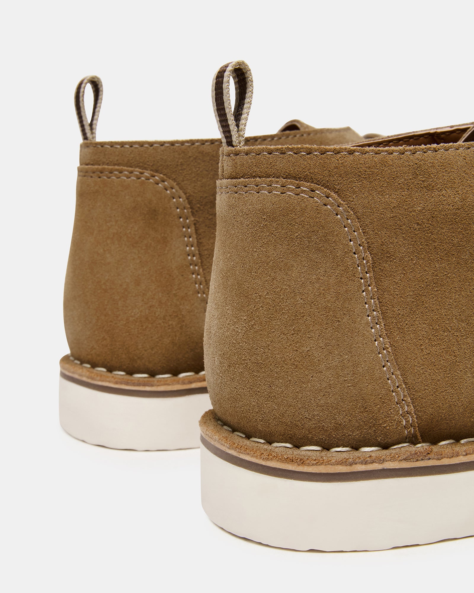 Side view of HERO cognac suede ankle boots on a wooden floor.