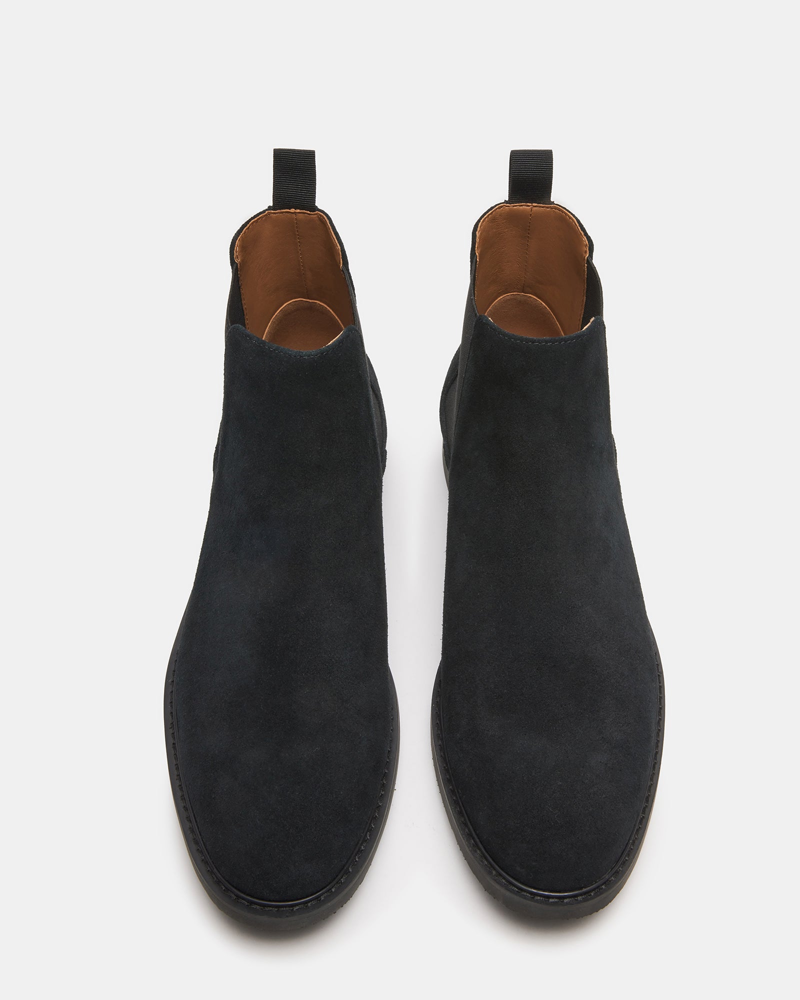 Side view of Highline black suede Chelsea boots on a model.