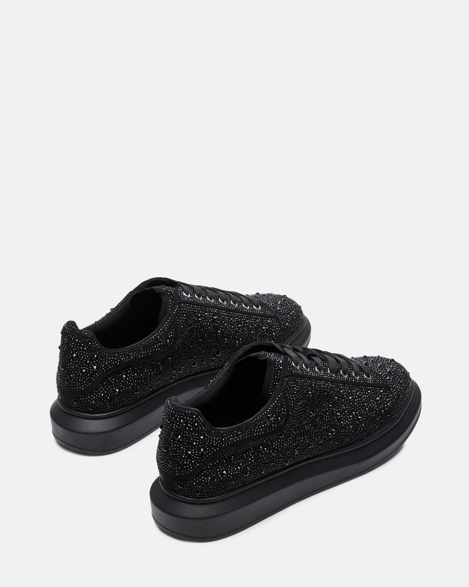 Lifestyle image of platform sneakers women love styled with ripped jeans on urban pavement