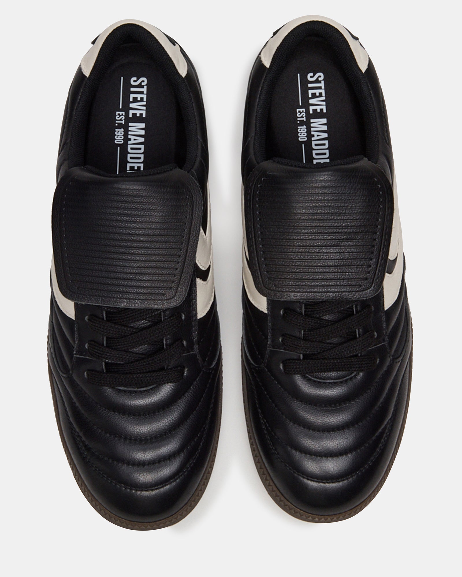 Detail shot of lace-up sneakers showcasing premium black leather finish