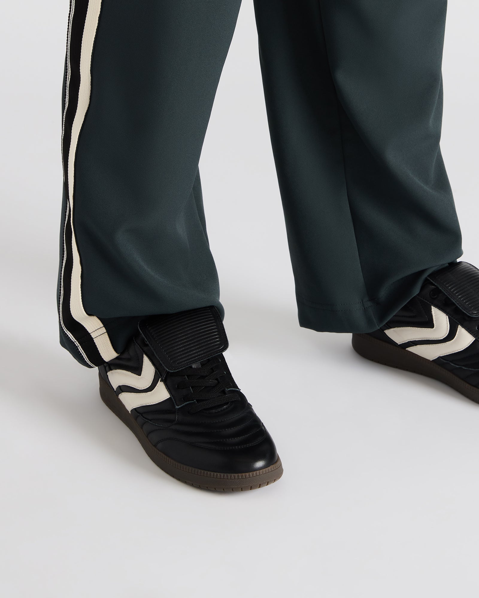 Detail shot of lace-up sneakers showcasing premium black leather finish