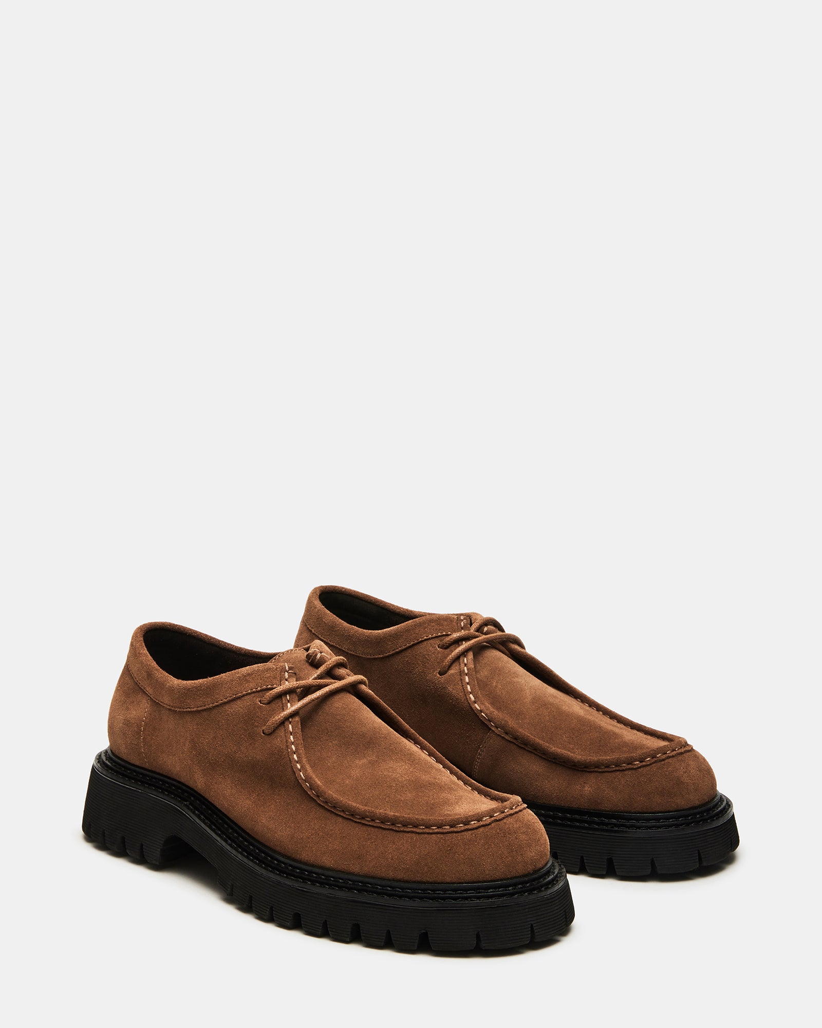 Overhead shot of Kalkin wallabee-style shoes paired with linen pants on a rooftop lounge in LA