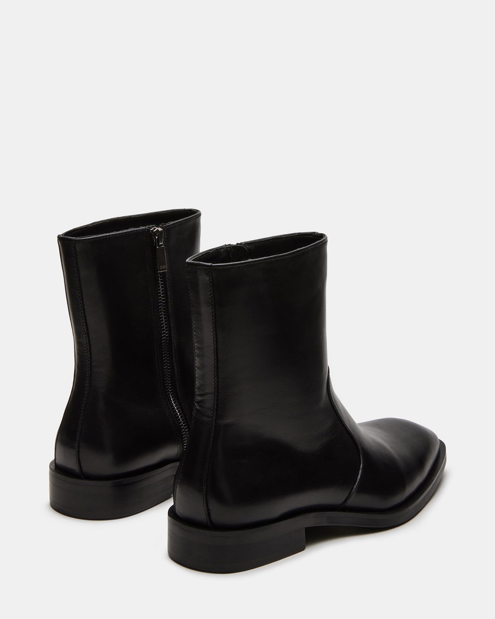 Close-up of leather knee-high boots showing detailed stitching and zipper