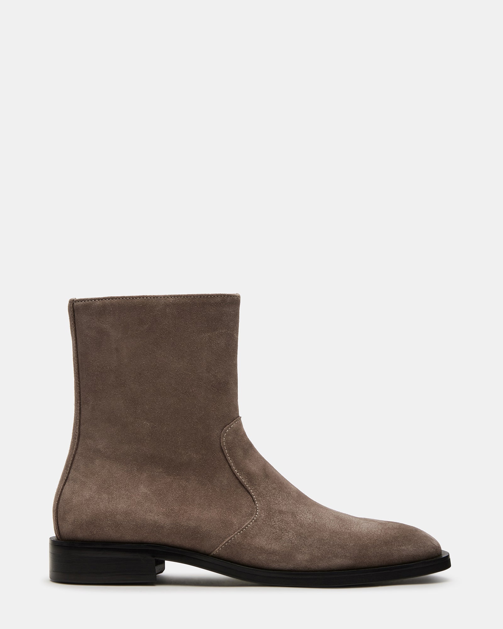 Front angle of suede cowboy boots styled with denim outdoors