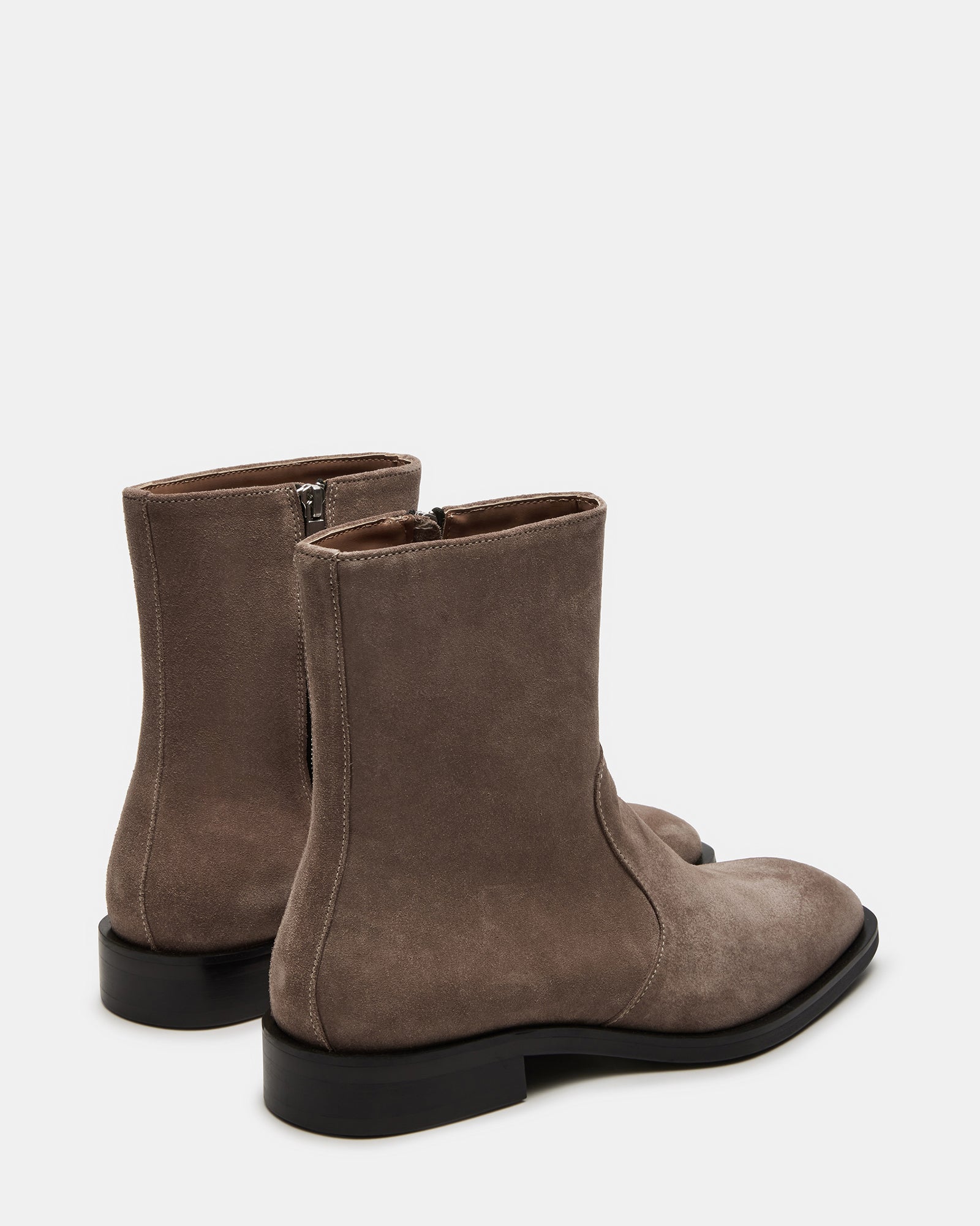 Side view of suede knee high boots with zipper detail near brunch table