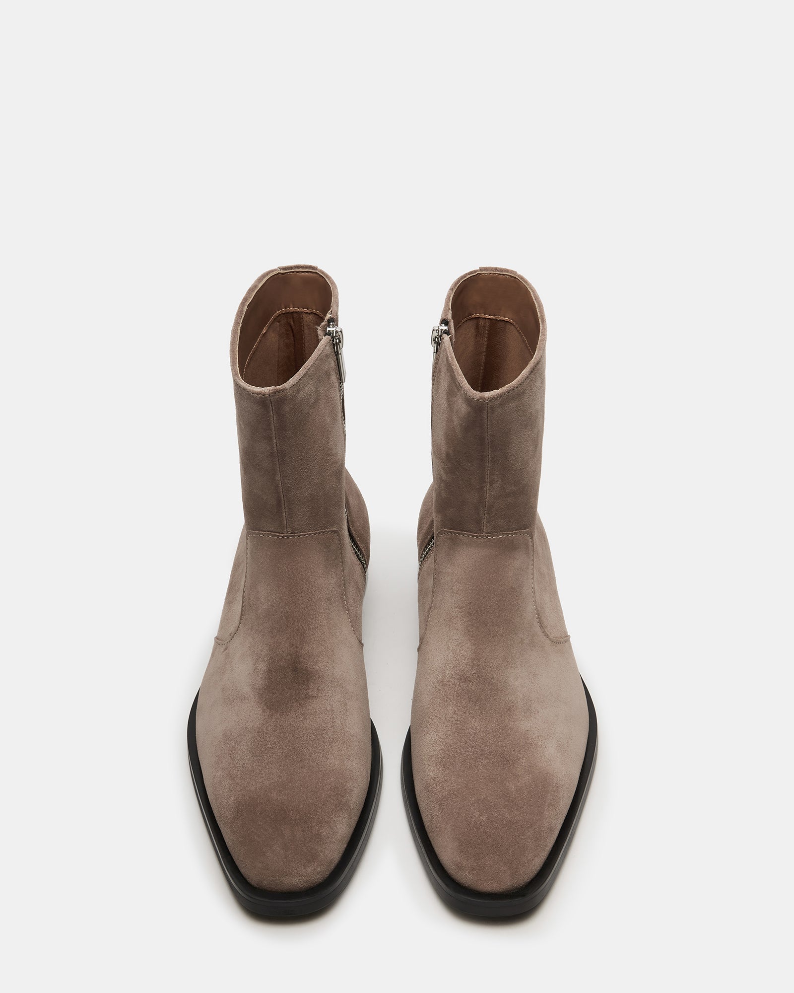 Front angle of suede cowboy boots styled with denim outdoors