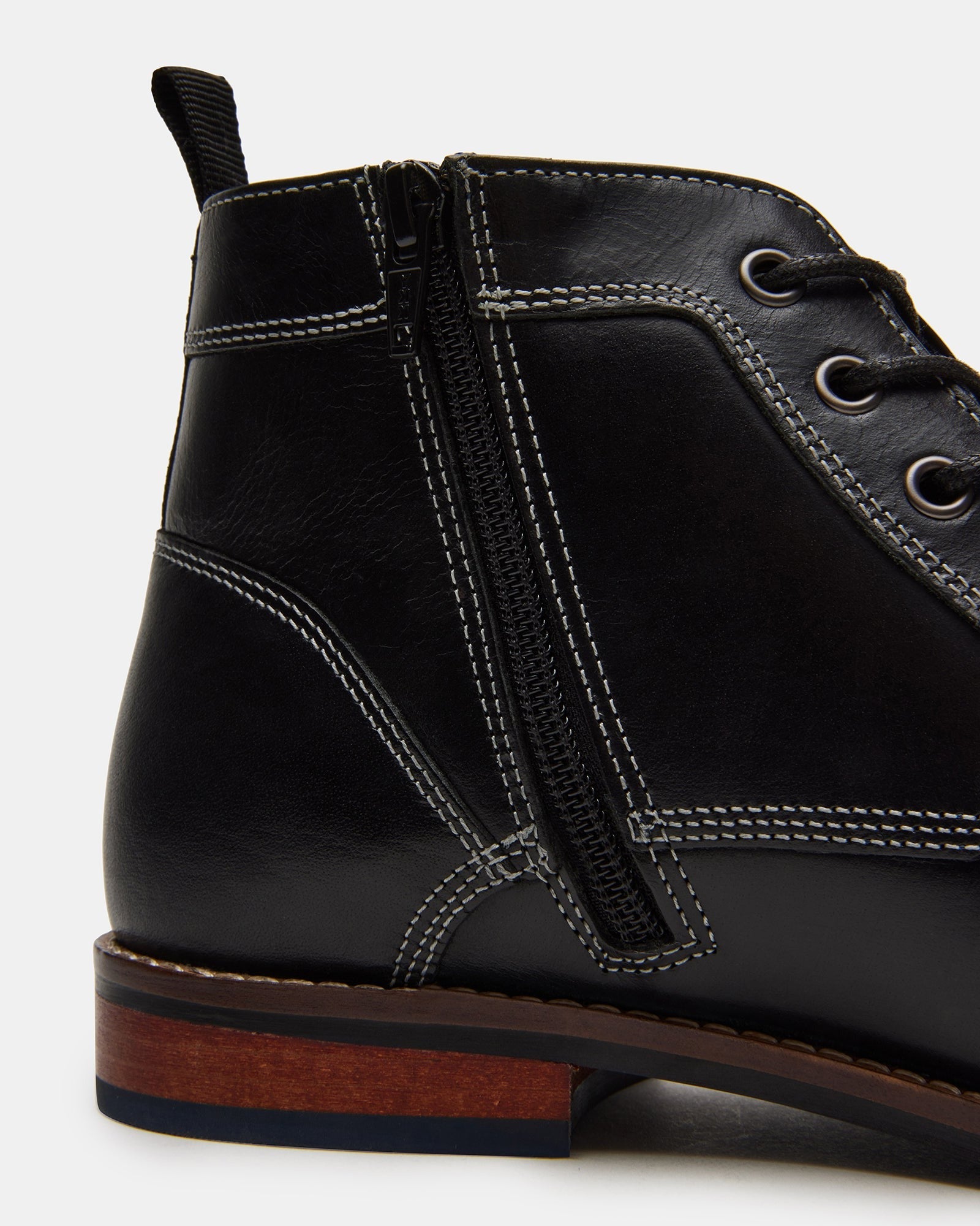 Black boots styled with denim in an urban outdoor setting