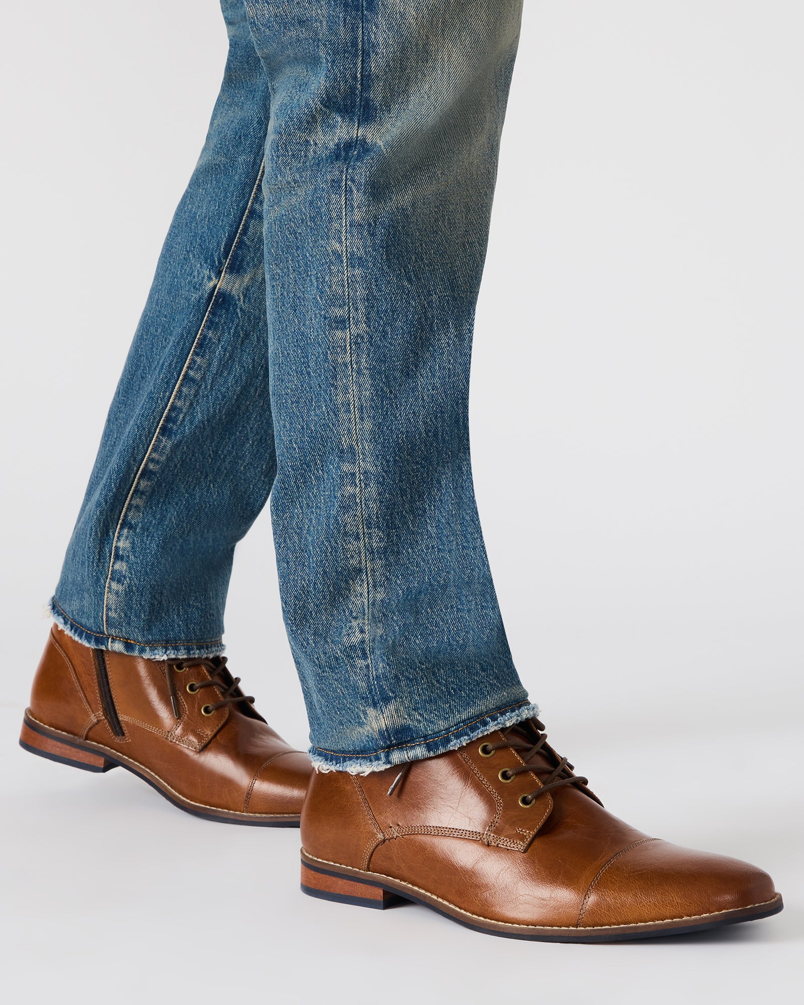 Top angle showing lace-up design and cap toe on black leather boots