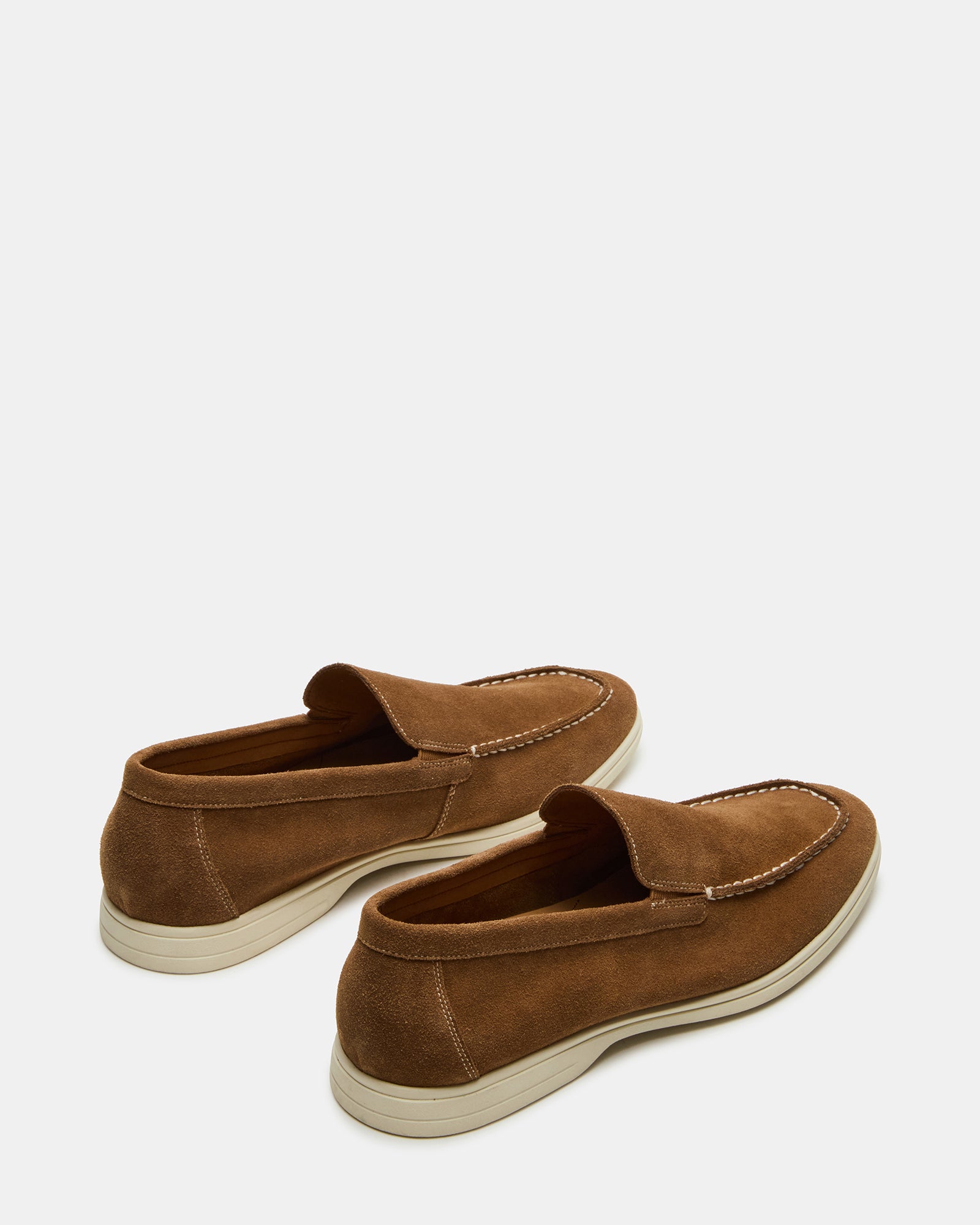 Men wearing LINUX brown suede slip-on shoes in a casual outdoor setting.