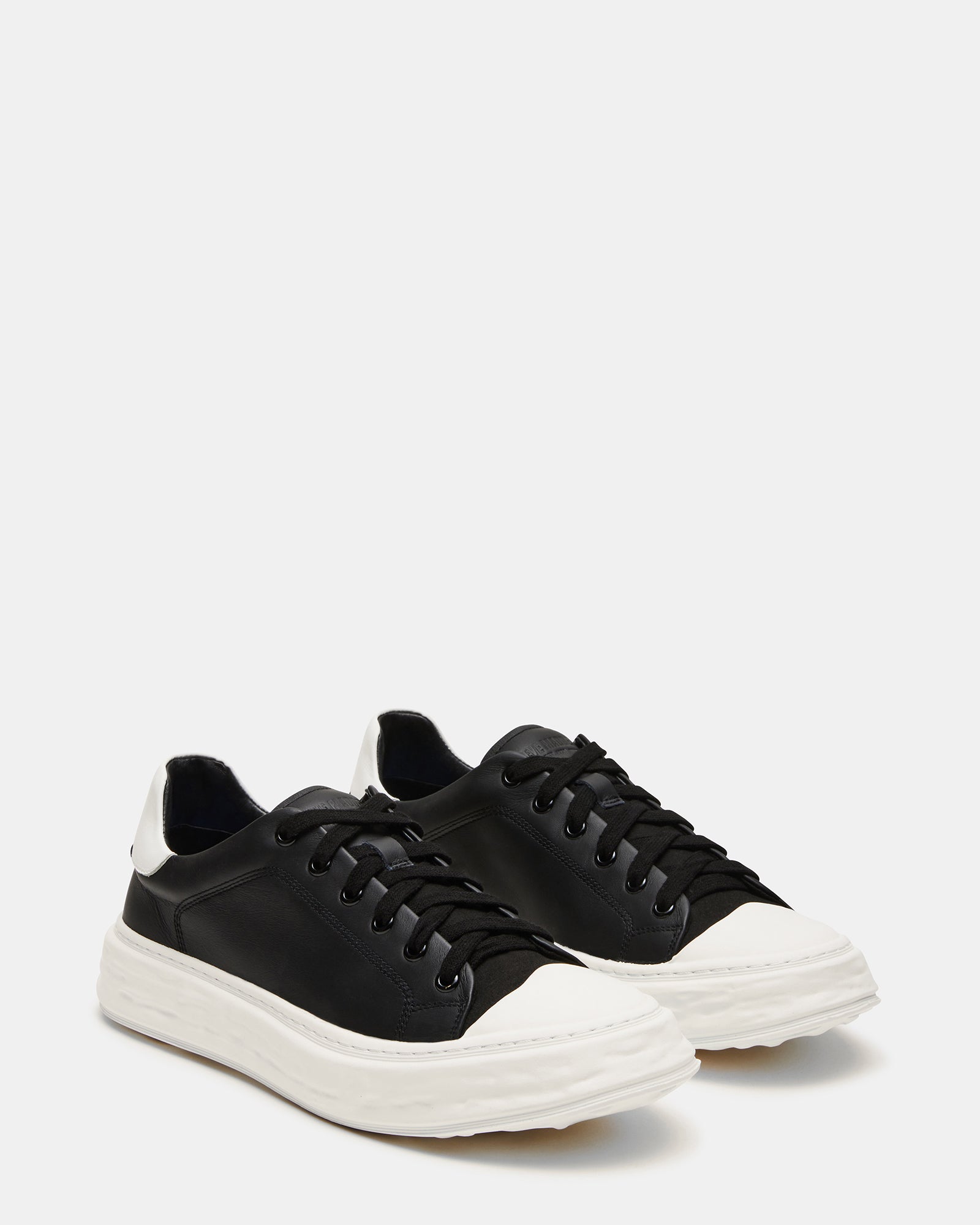 Top-down view of mens white sneakers with lace-up closure and textile lining