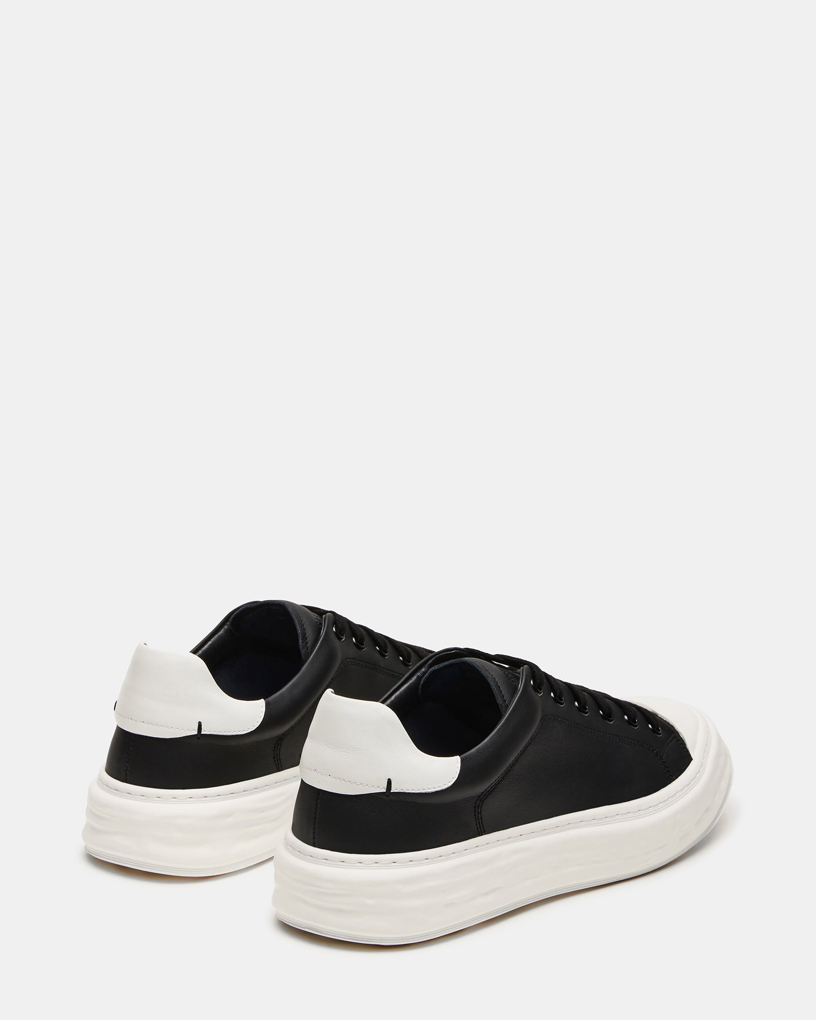 Top-down view of mens white sneakers with lace-up closure and textile lining
