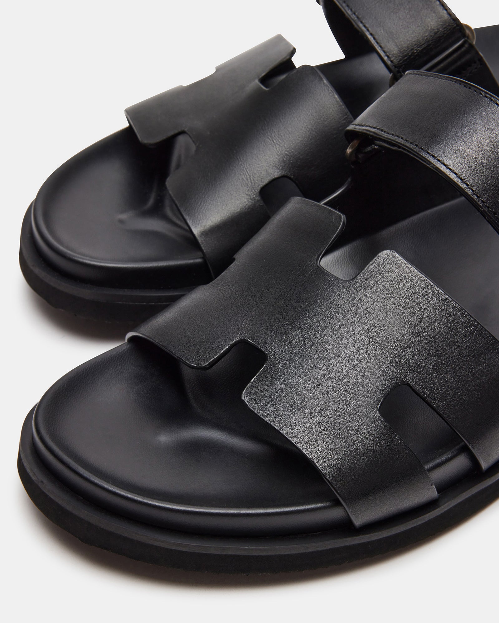 Close-up of black leather sandals with slip-on design and 1.5-inch heel, ideal for summer wear