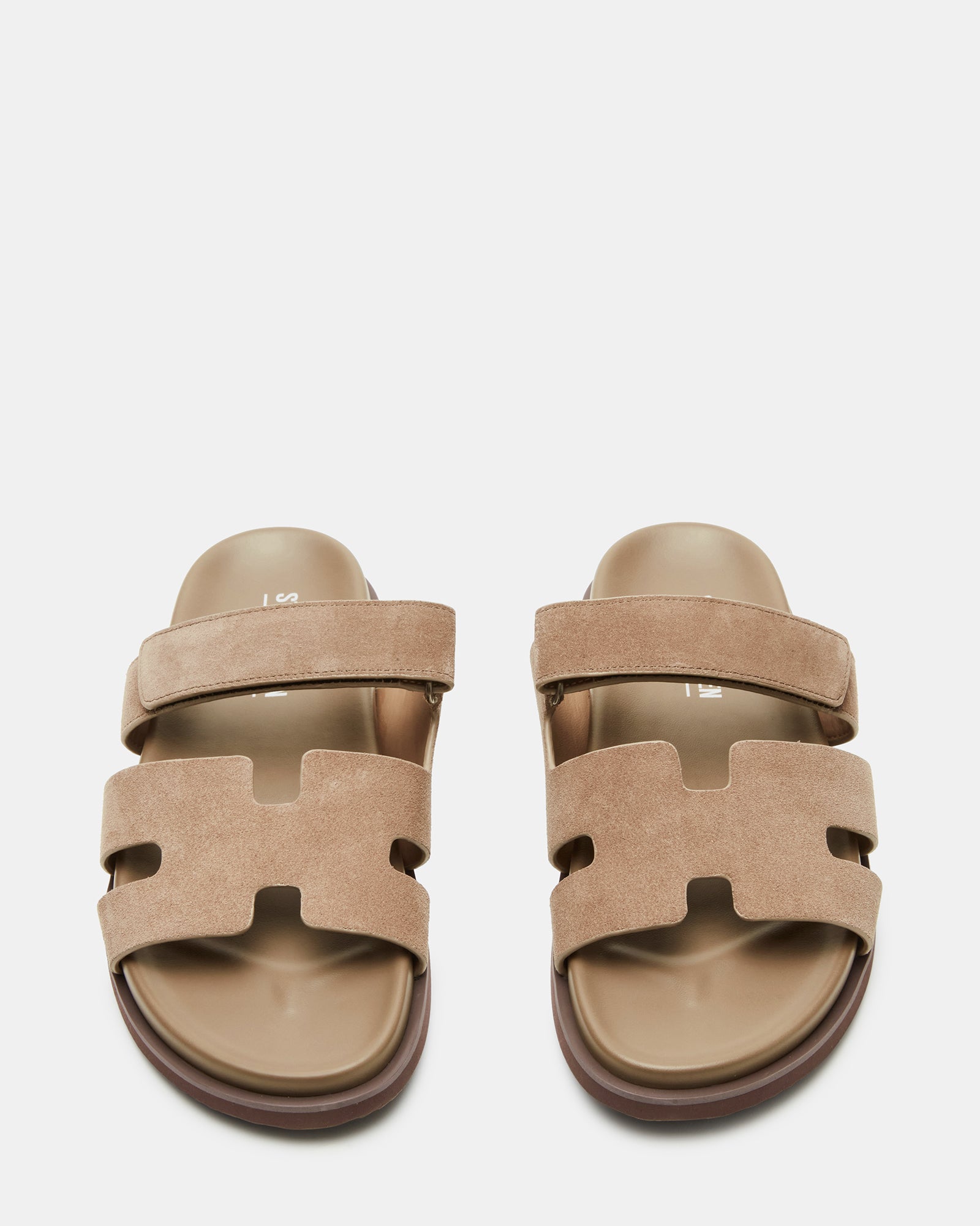 Model wearing taupe suede slides at a summer beach party, demonstrating versatility.
