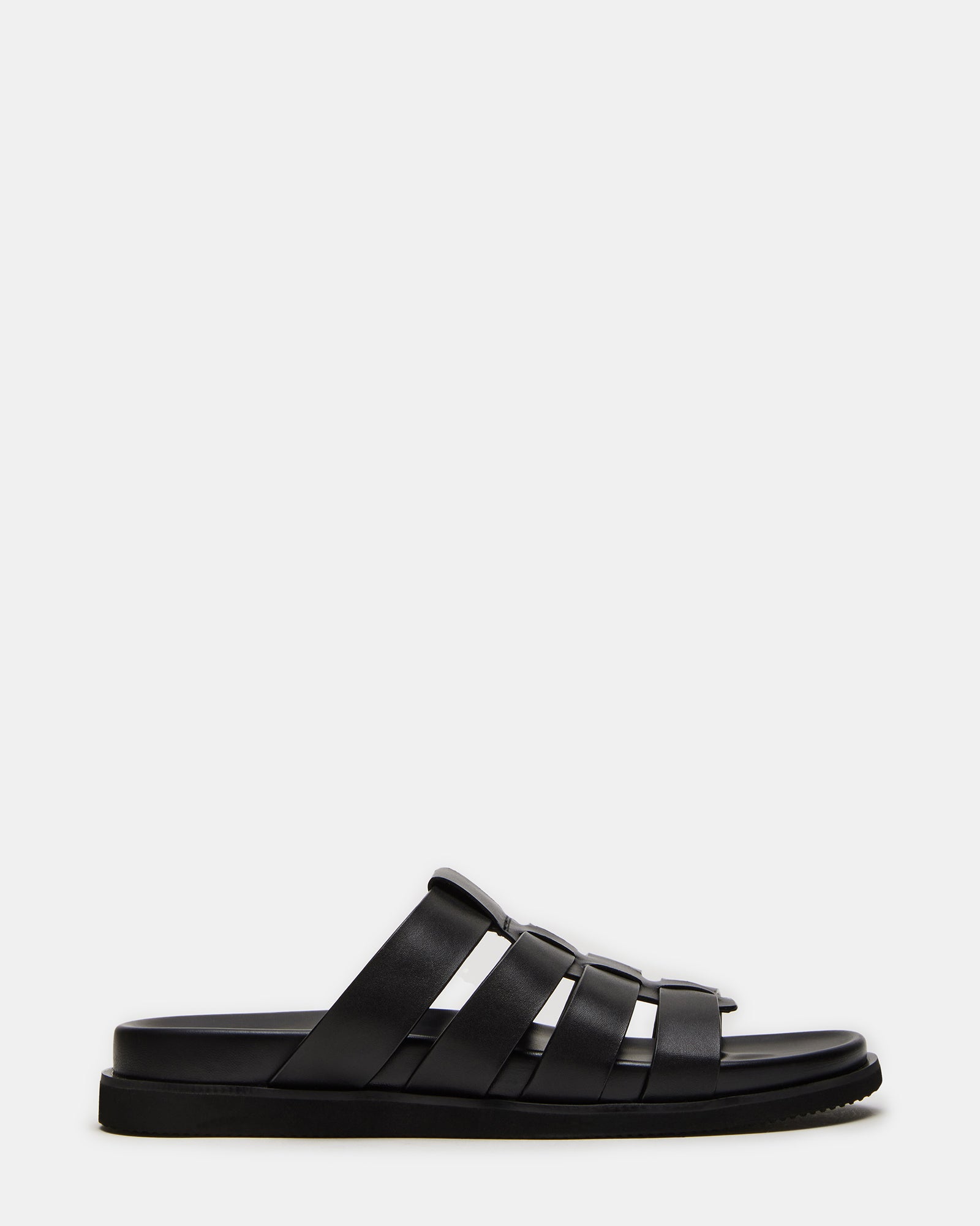 Marvyn black leather sandals on a rustic wooden background