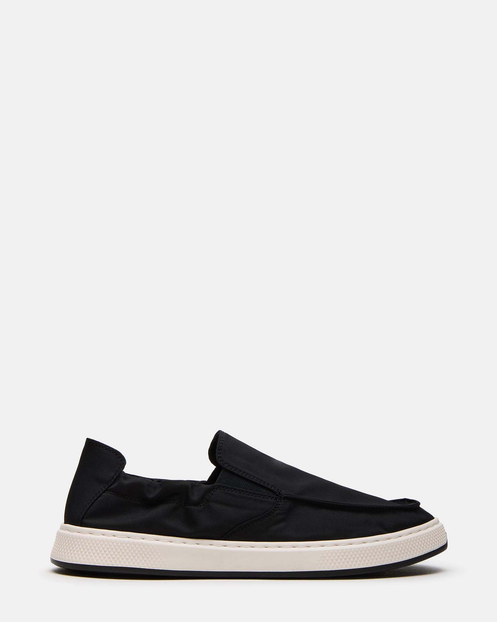 Side profile of black mens loafers on a hardwood floor