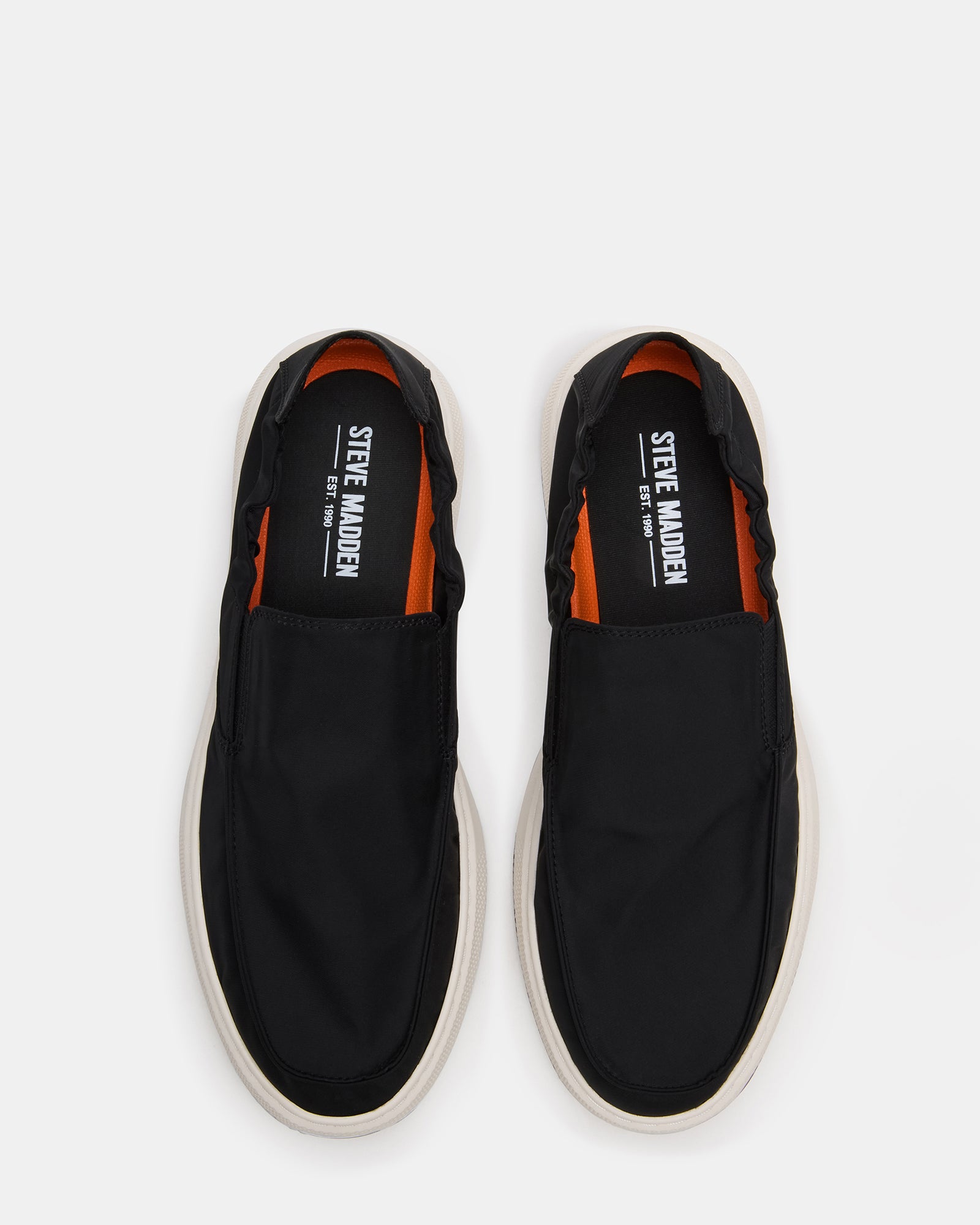Side profile of black mens loafers on a hardwood floor