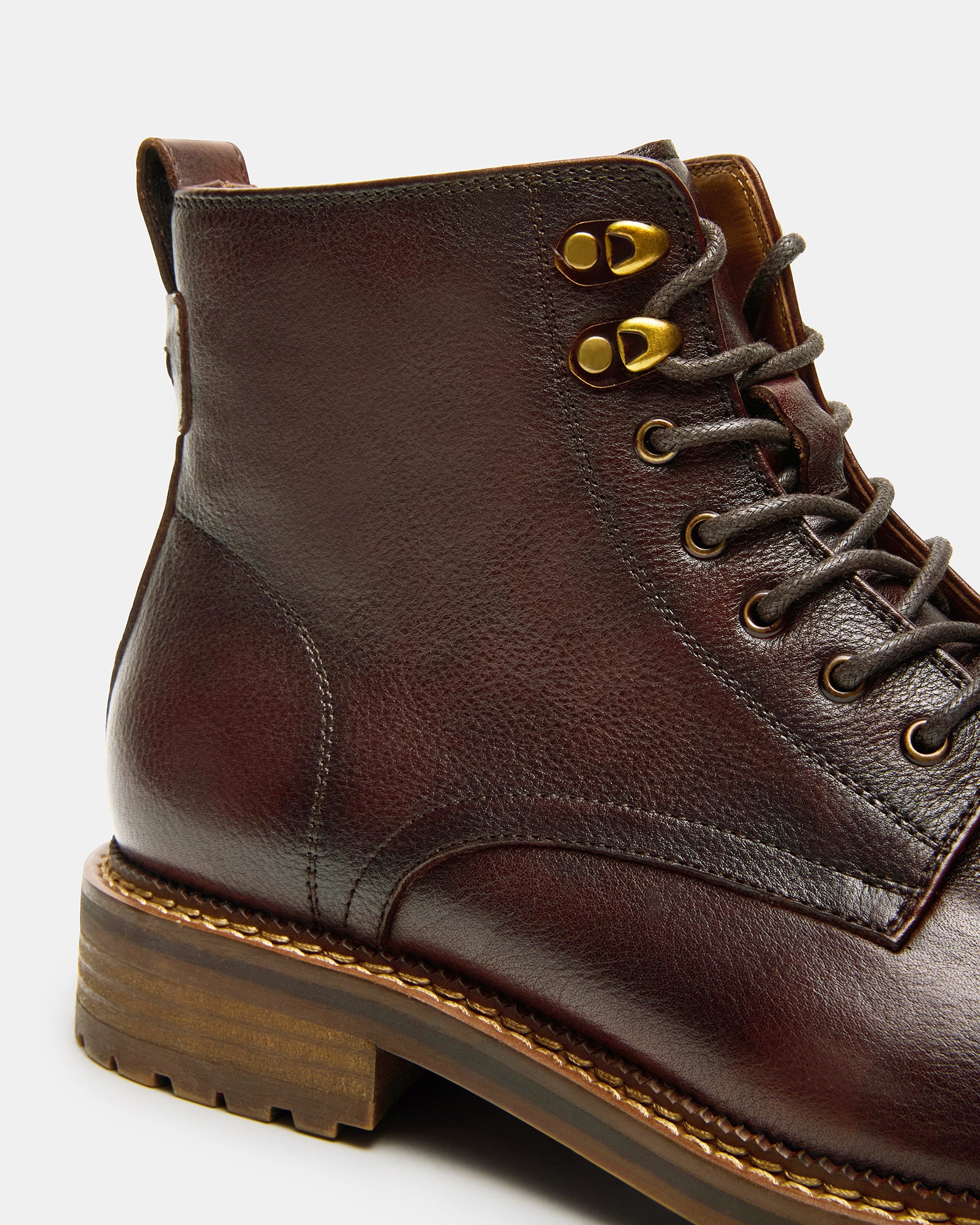 Brown lace up boots photographed outdoors on a stone path — ideal for fall outfits