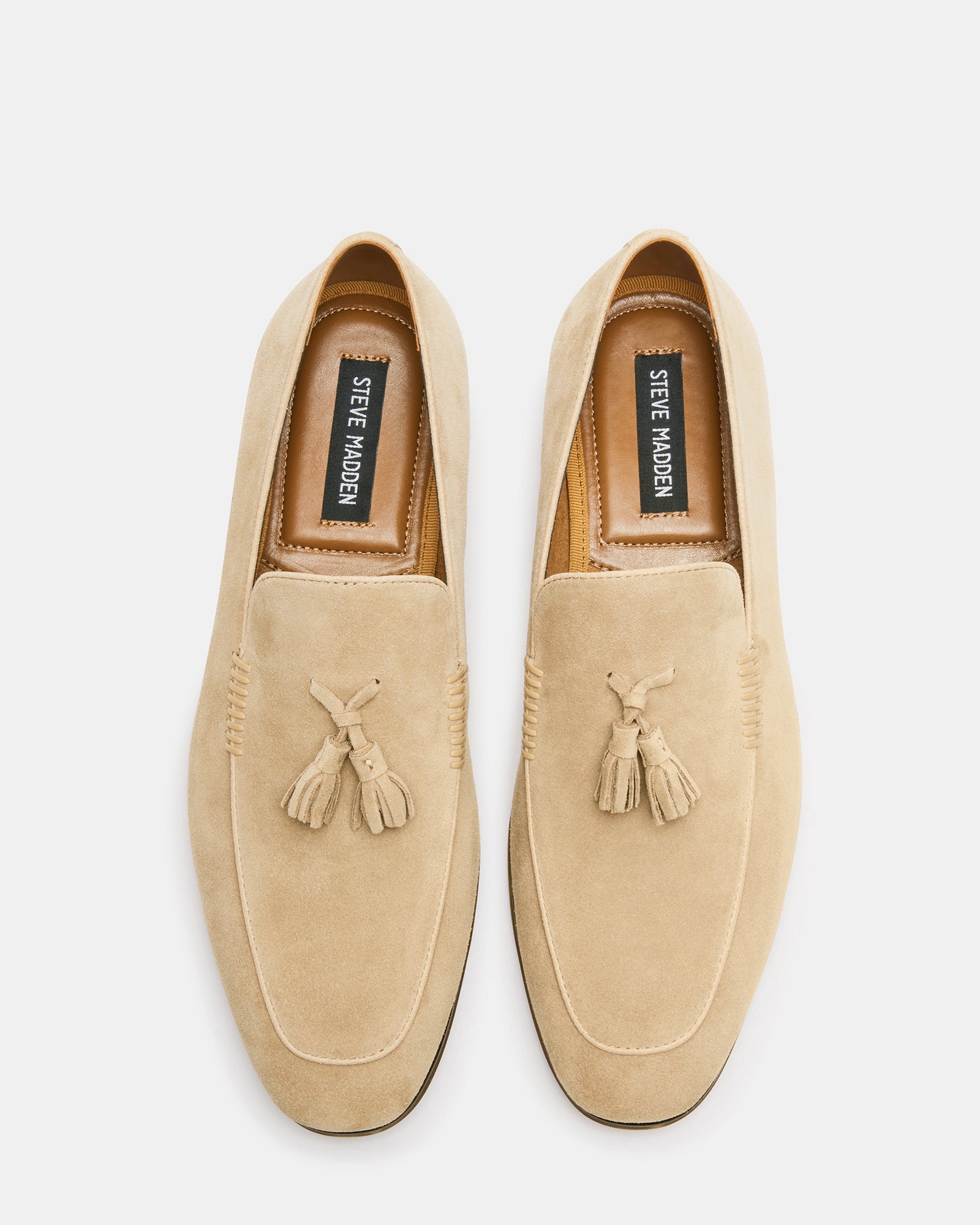 Side view of suede penny loafers on a wooden floor, showcasing the sleek profile