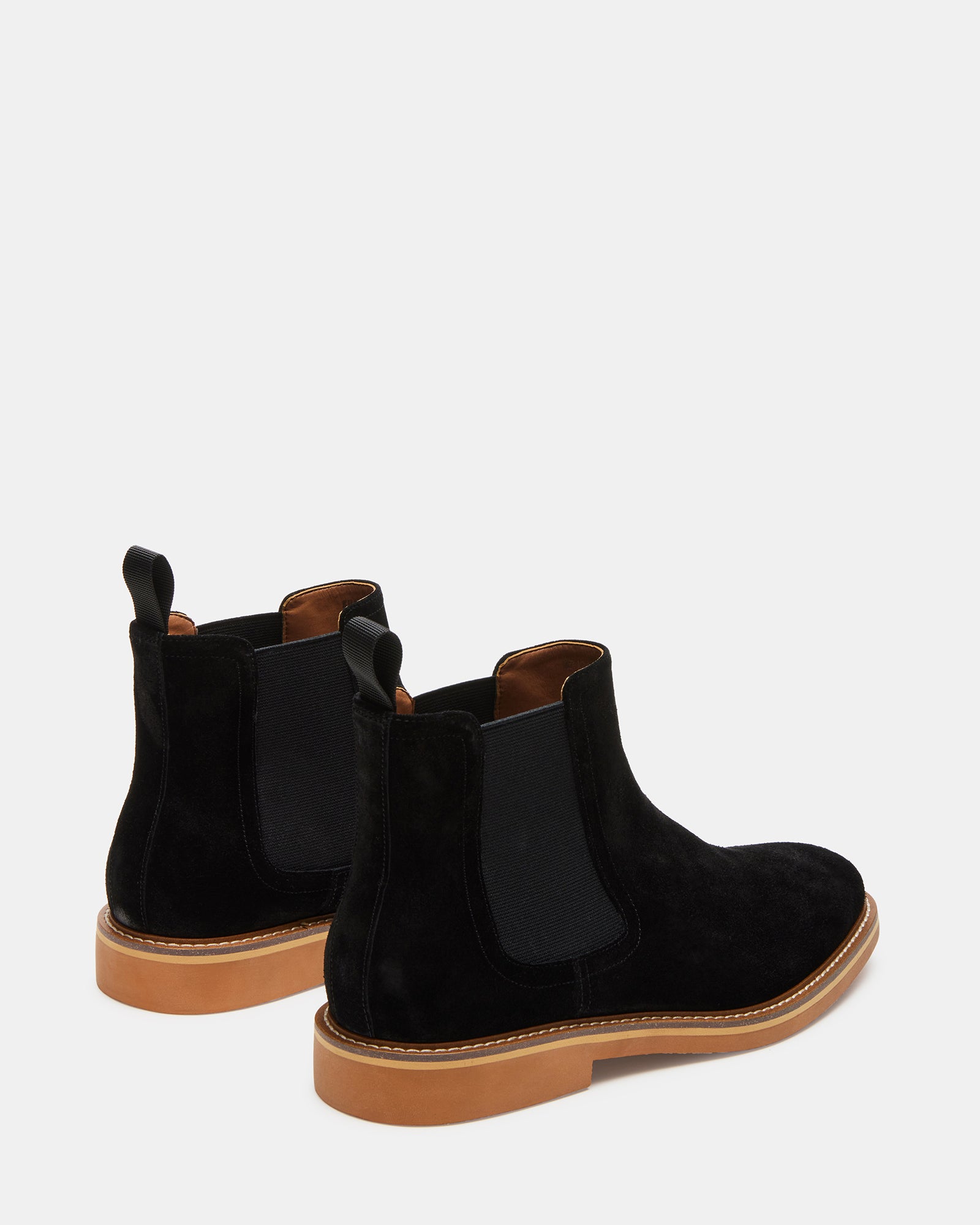 Outdoor lifestyle image showing womens ankle boots worn with jeans near a park bench
