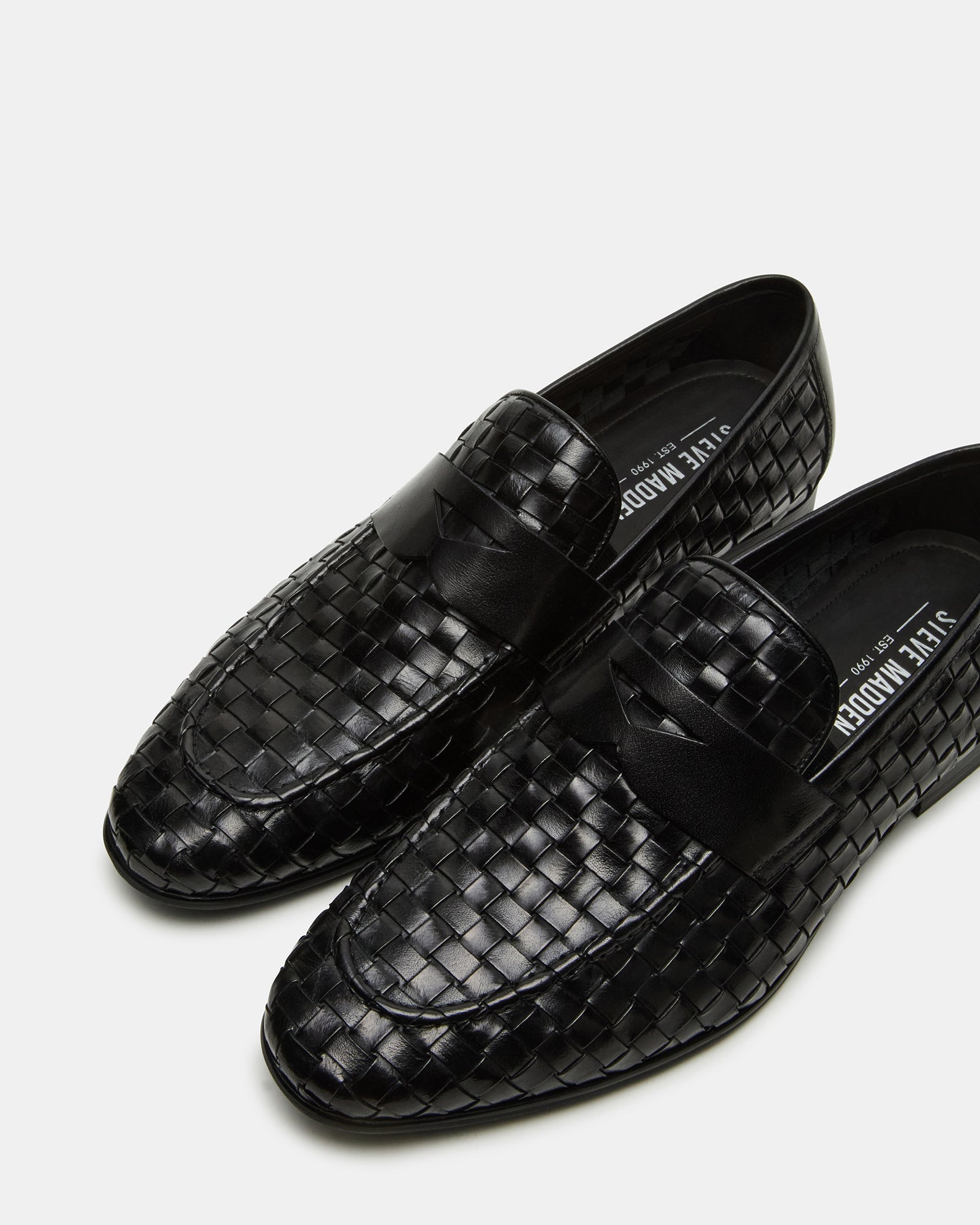 Side view of Poco black leather loafers on display, emphasizing the unique woven pattern.
