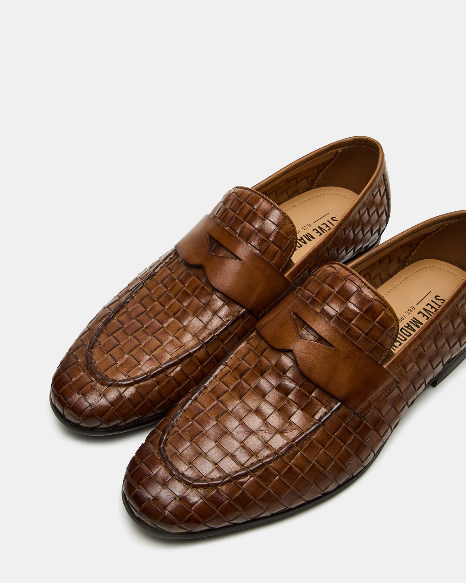 Lifestyle shot of penny loafers worn with tailored trousers in a city setting