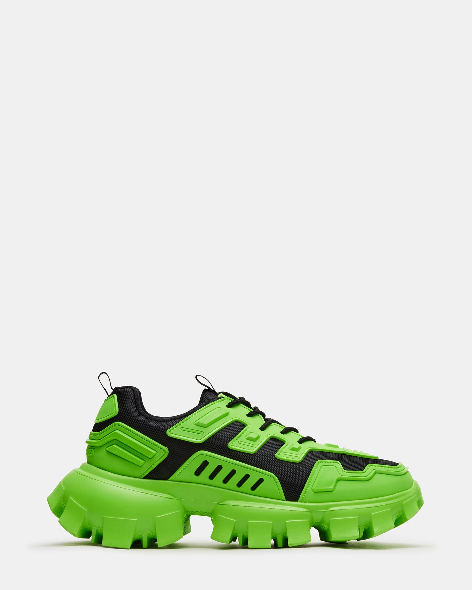Neon green running sneakers styled with urban streetwear, showcasing the chunky sole detail