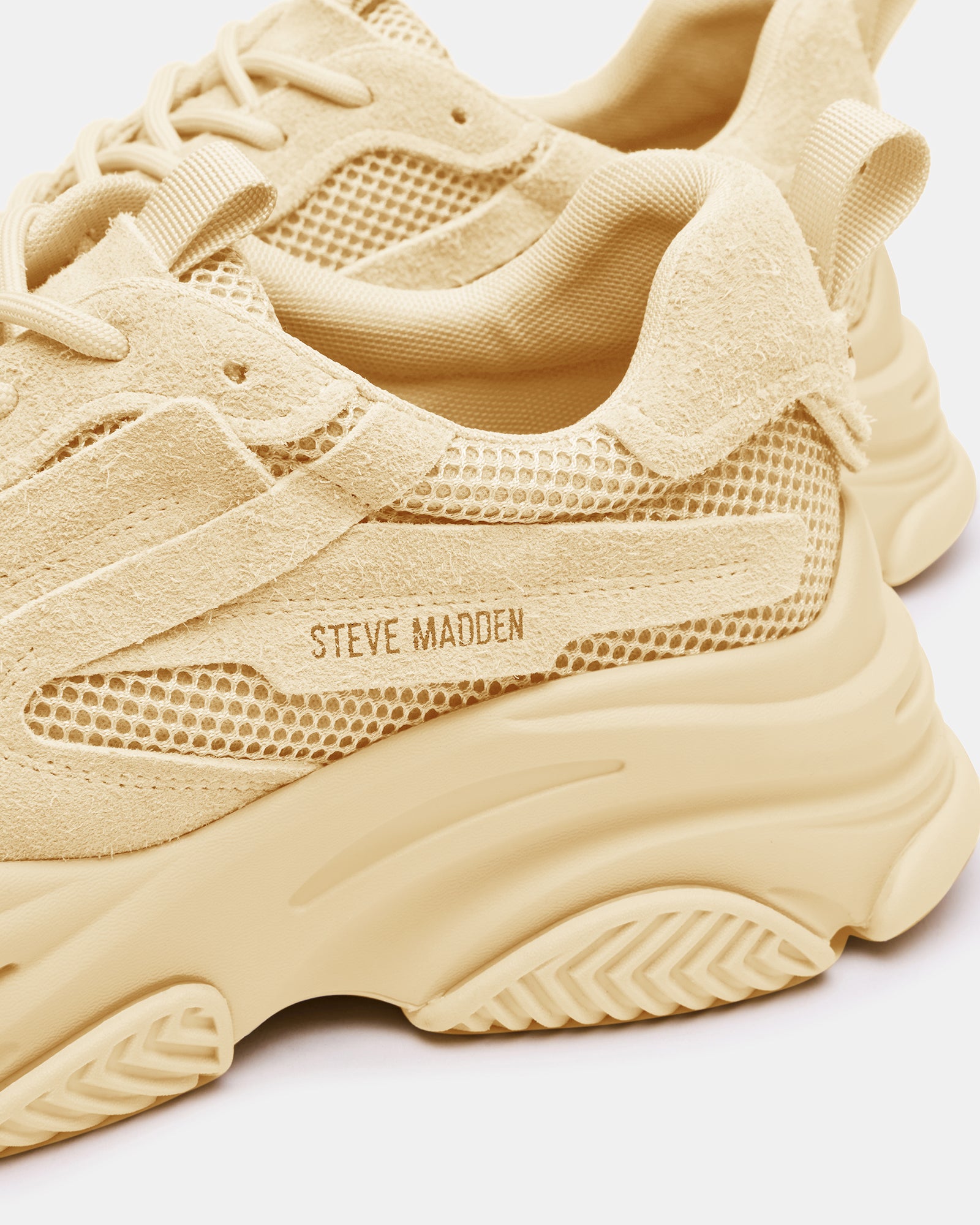 Side view of taupe chunky sneakers showcasing the molded sole and laced closure.