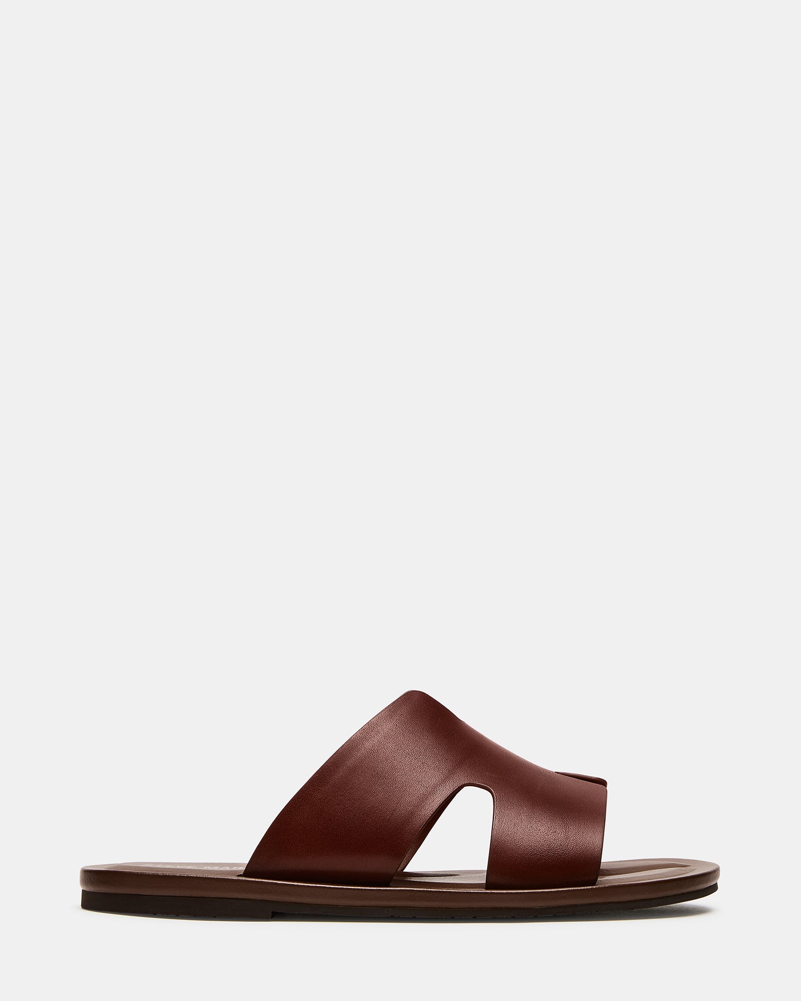 Side view of brown leather sandals on a rustic boardwalk
