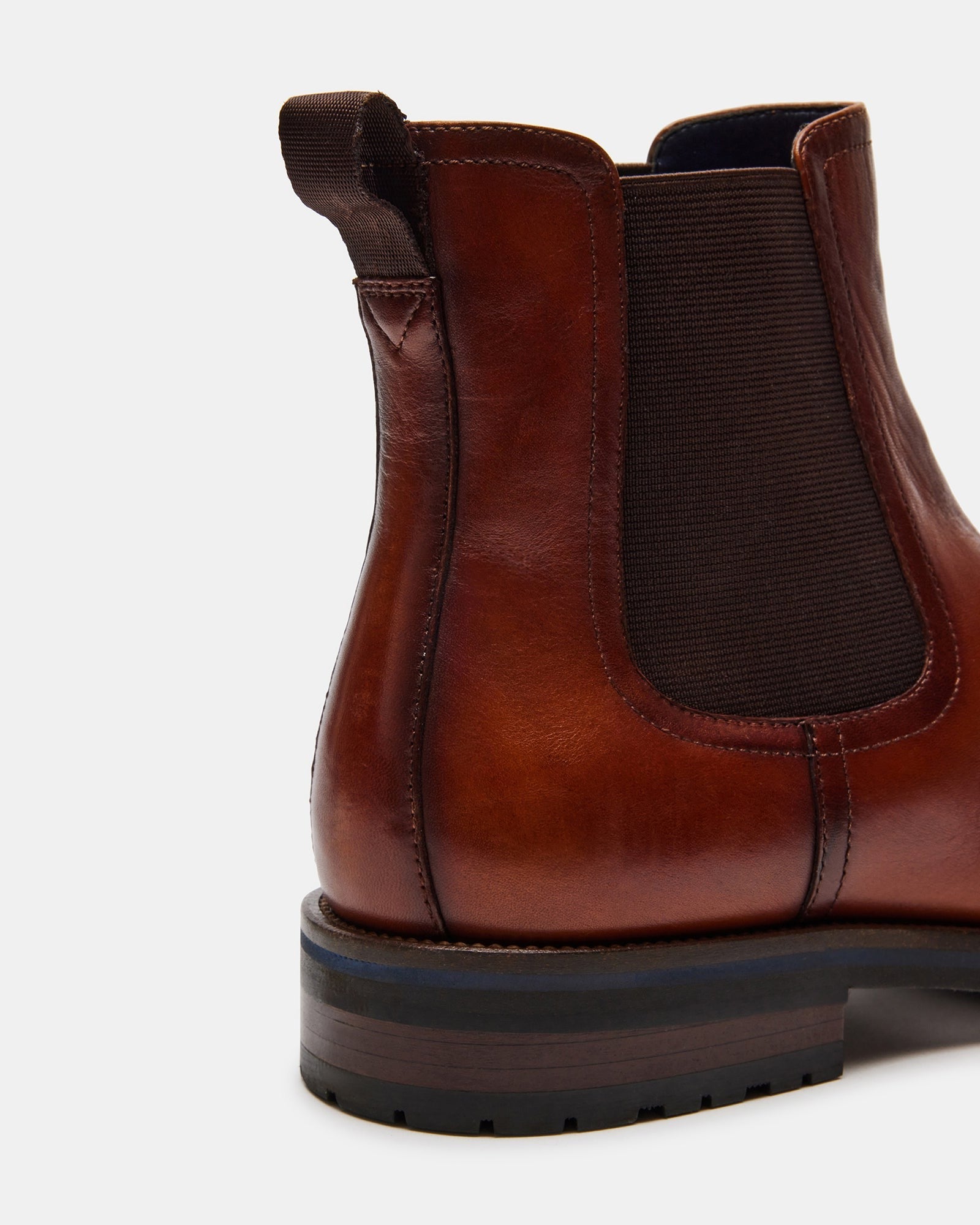 Front view of SYRE tan leather pull-on boots on a city street