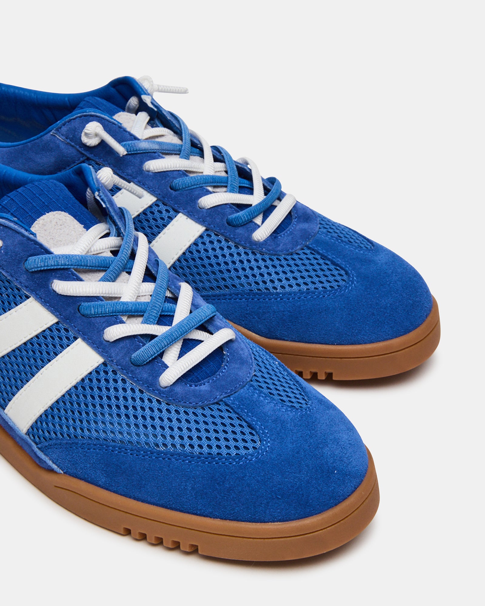 Blue multi-color sneakers on feet, walking on pavement