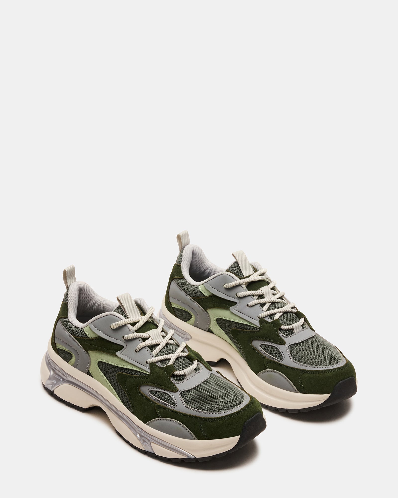 Green suede sneakers styled with an outfit, demonstrating versatility for various occasions.