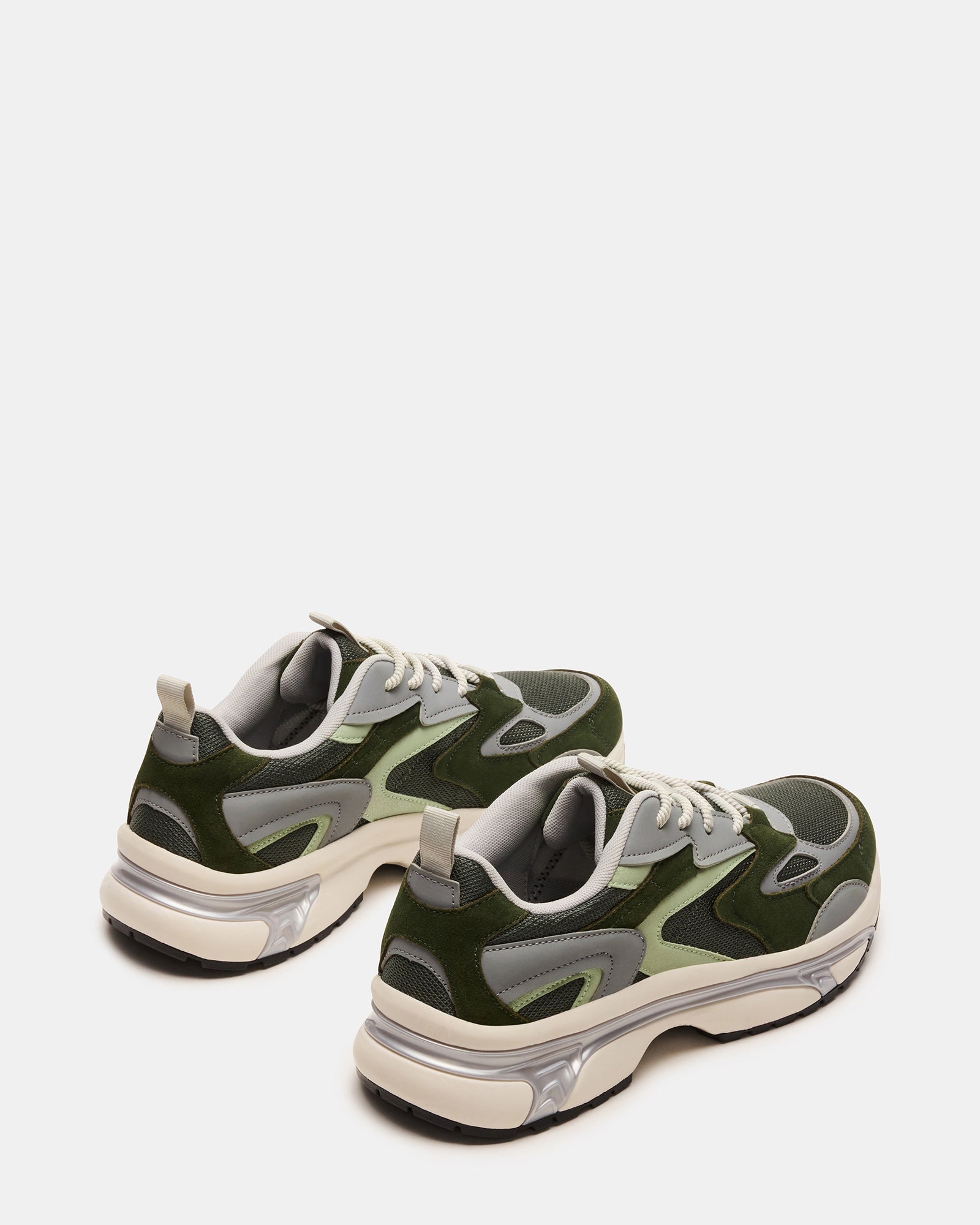 Green suede sneakers styled with an outfit, demonstrating versatility for various occasions.