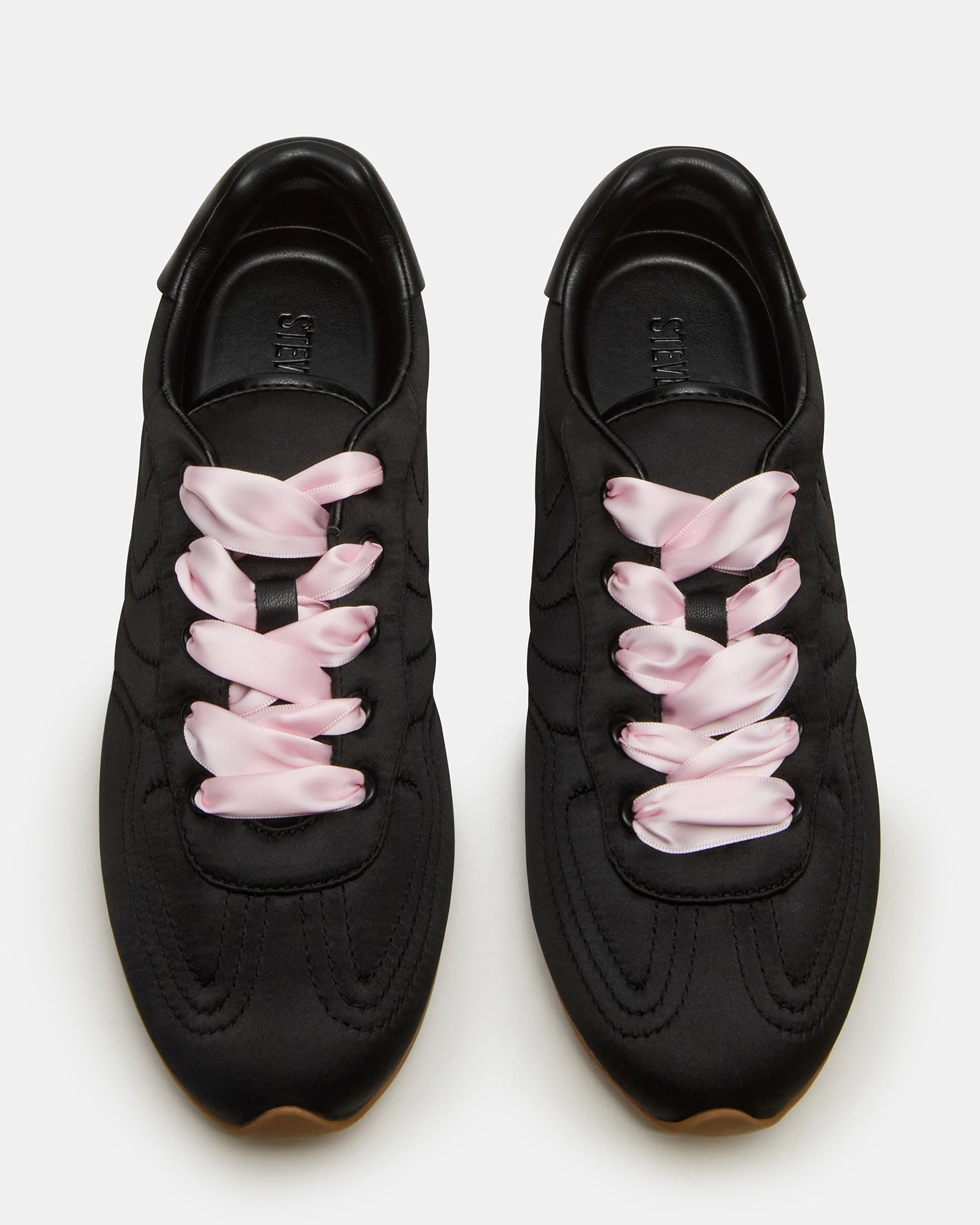 ABBI black satin sneakers from a side angle, showcasing the sleek texture and lace-up design