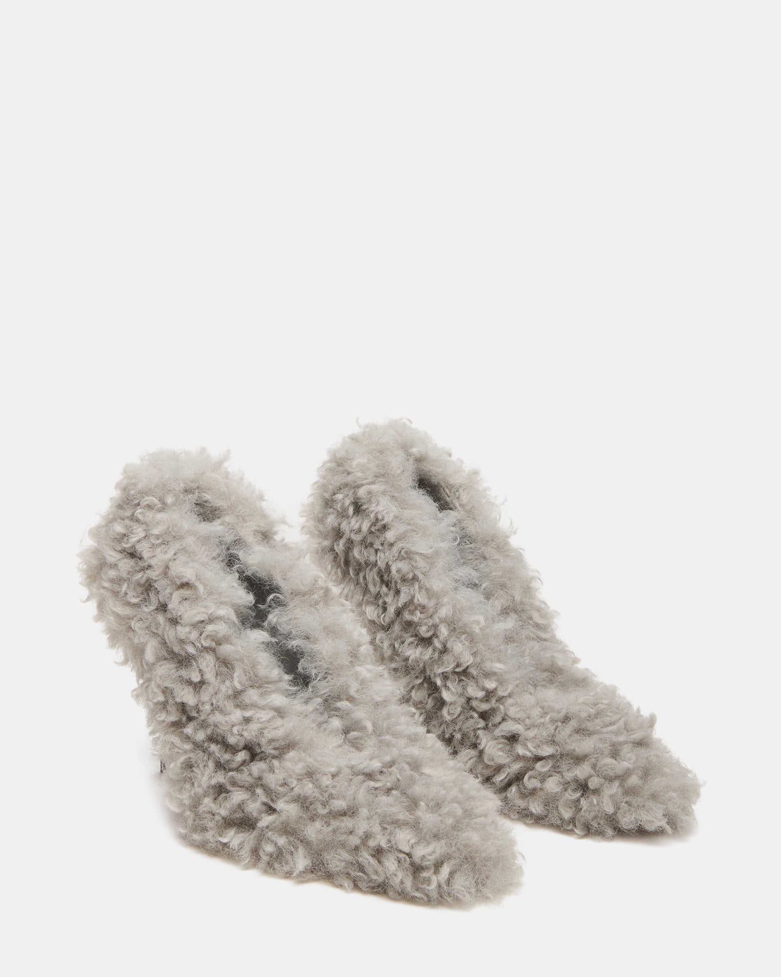 Side angle view showing the elegant arch and heel height of white stiletto heels