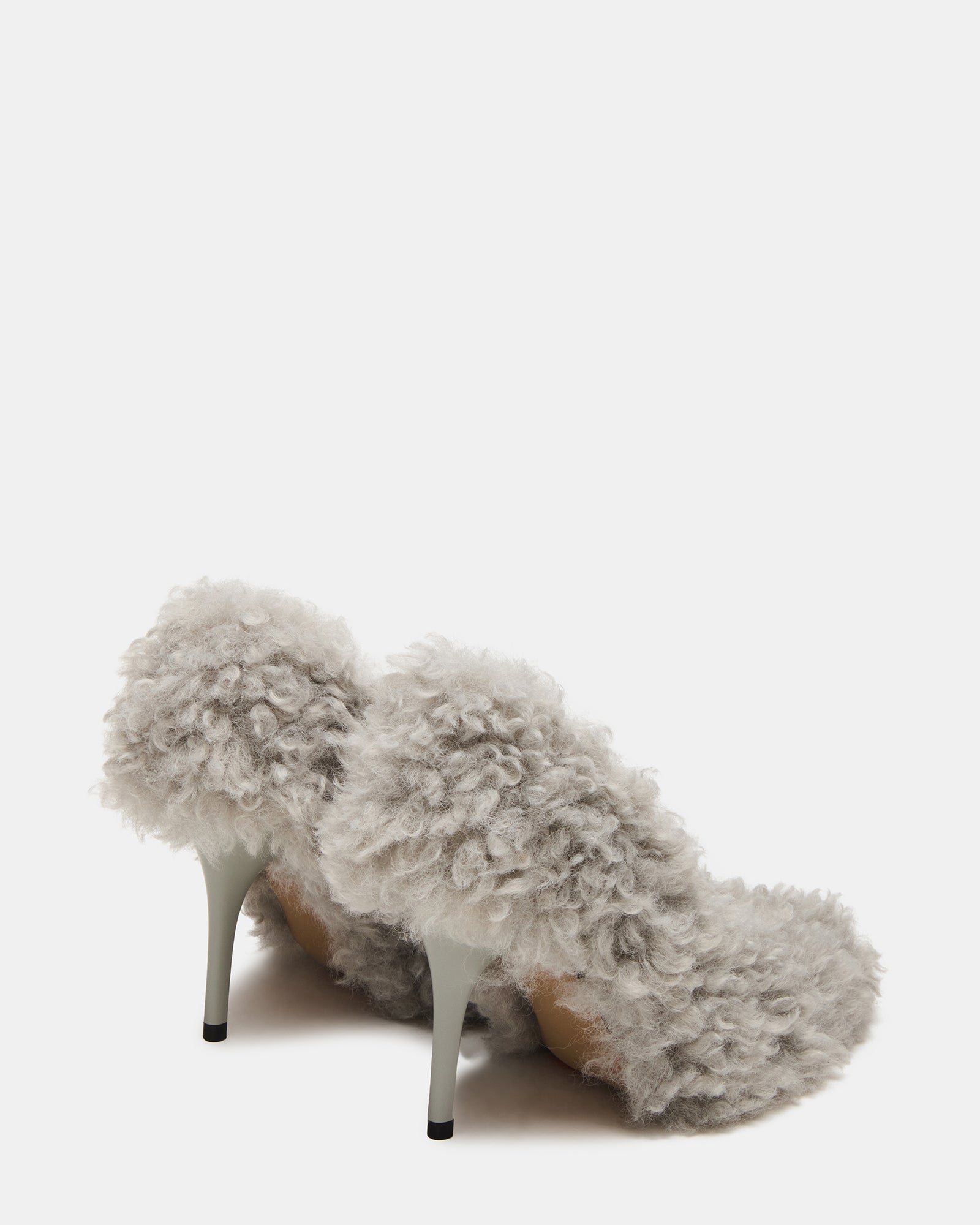 Side angle view showing the elegant arch and heel height of white stiletto heels