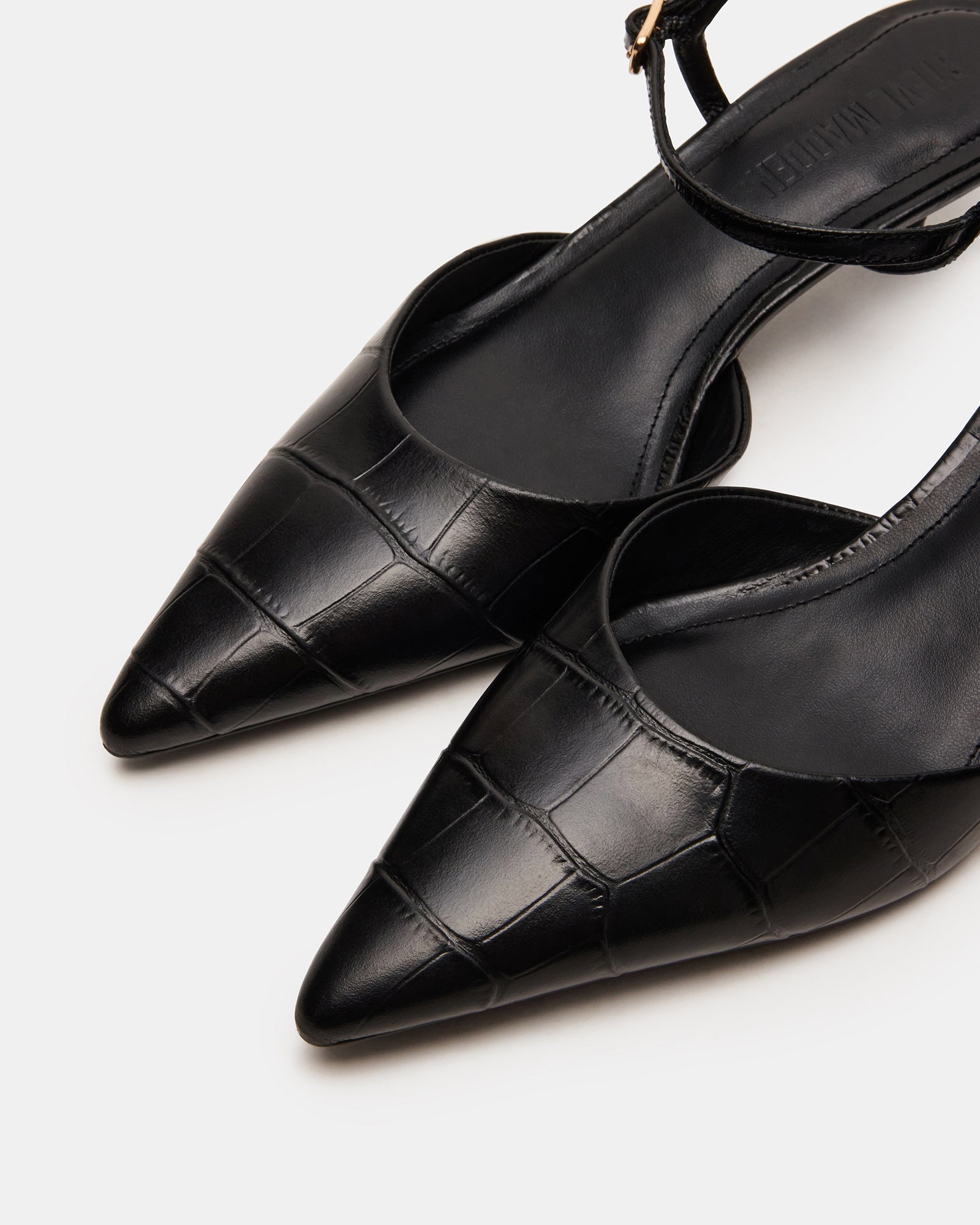 Model wearing black pointed toe heels at a stylish event.
