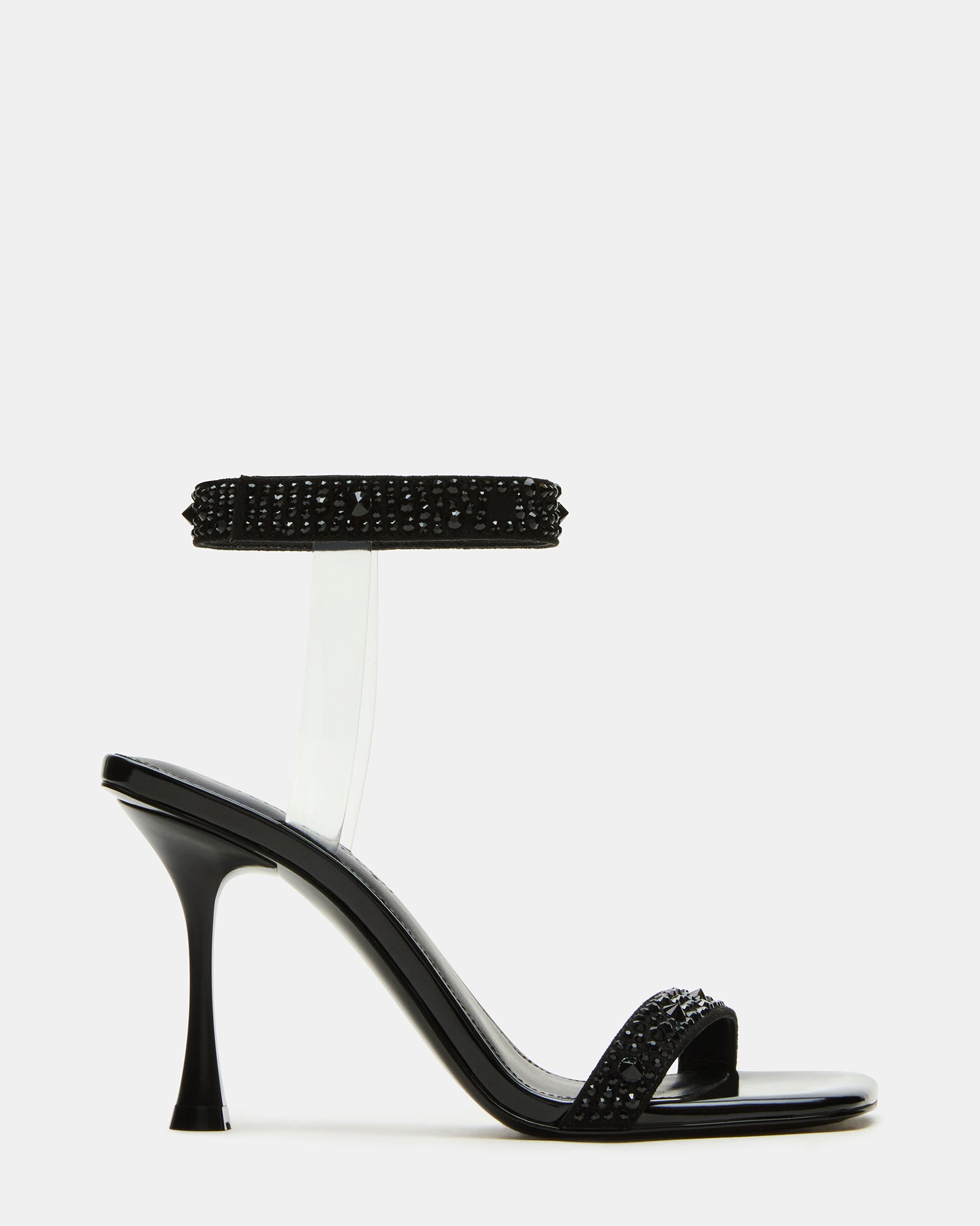 Close-up of black heels with rhinestones on heel and ankle strap around model's foot