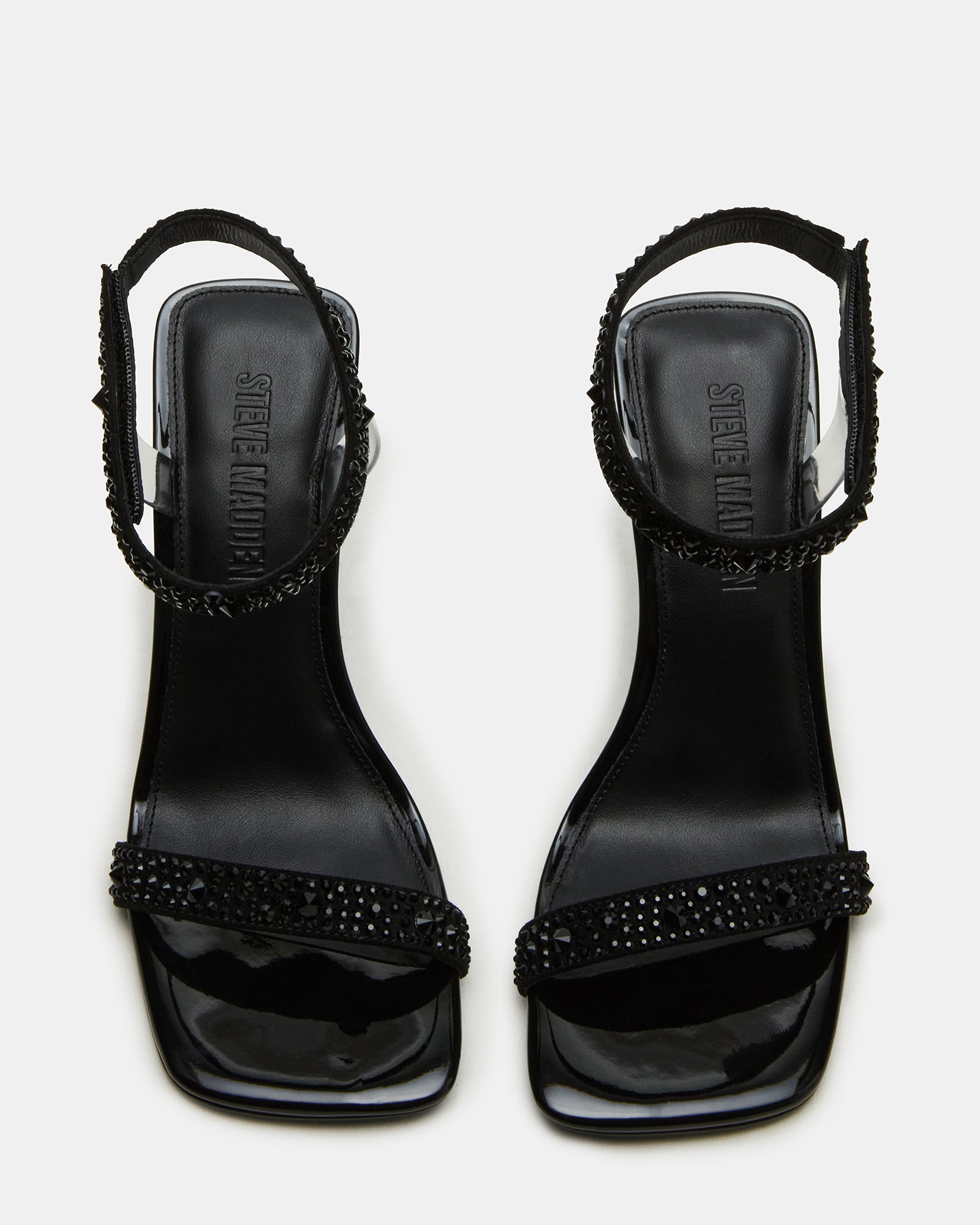 Close-up of black heels with rhinestones on heel and ankle strap around models foot