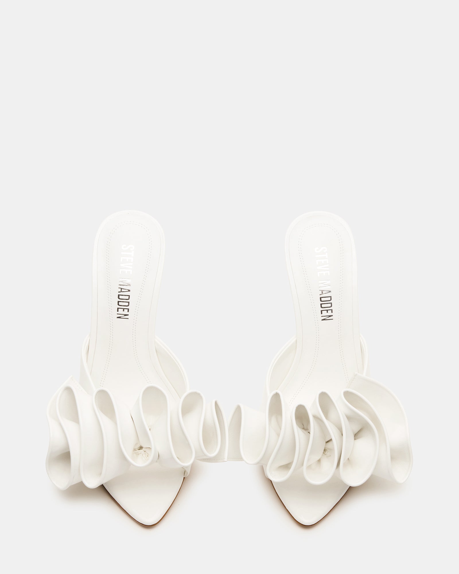 Close-up of the sleek mule silhouette of white stiletto heels.