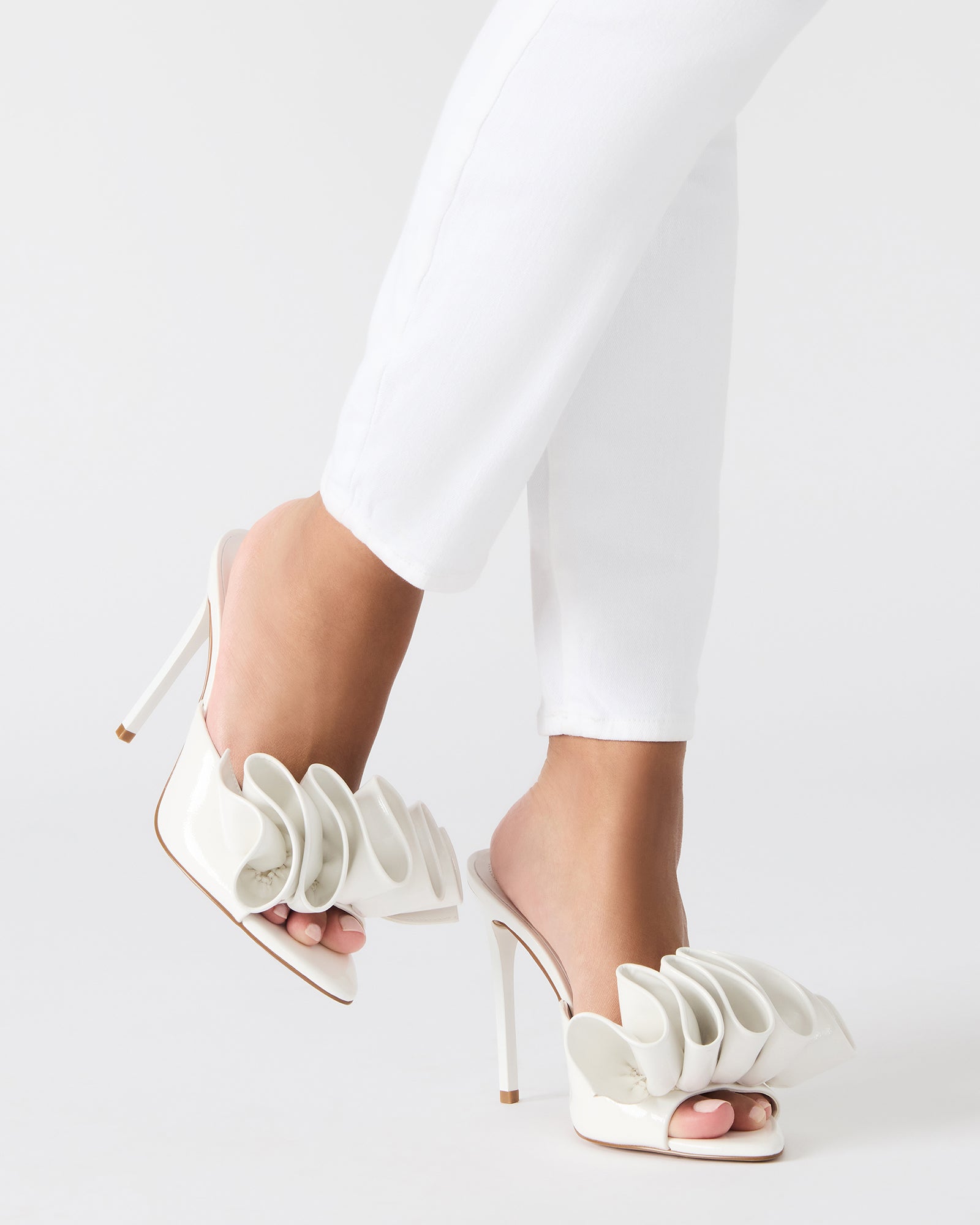Mules stiletto heels styled with evening wear on cobblestone street