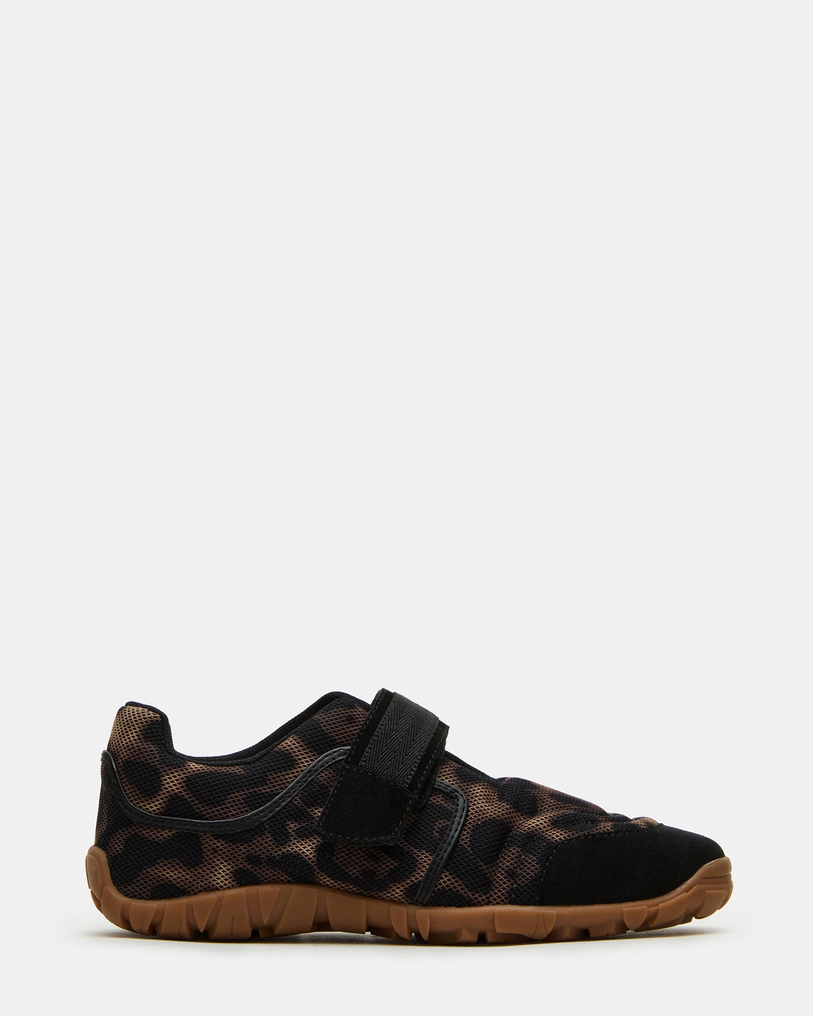 Side view of Mary Jane shoes with Velcro strap on textured sidewalk