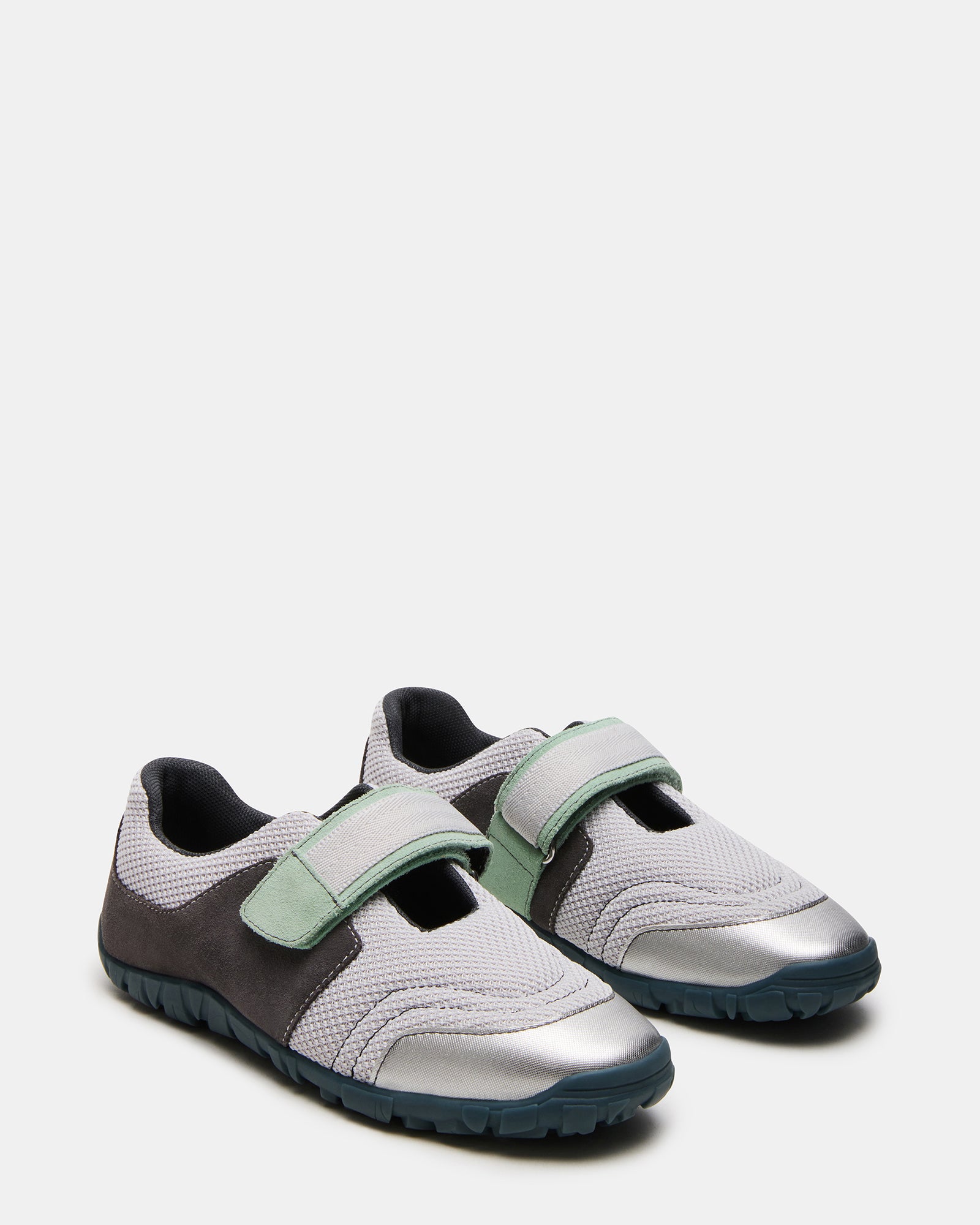Side view of low top sneakers highlighting the Velcro closure and stylish appearance.