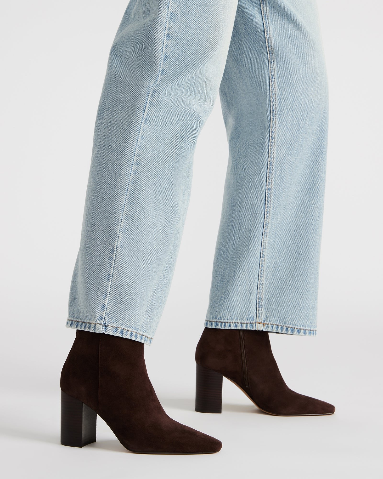 Side view of brown suede booties styled with rolled jeans for a casual look